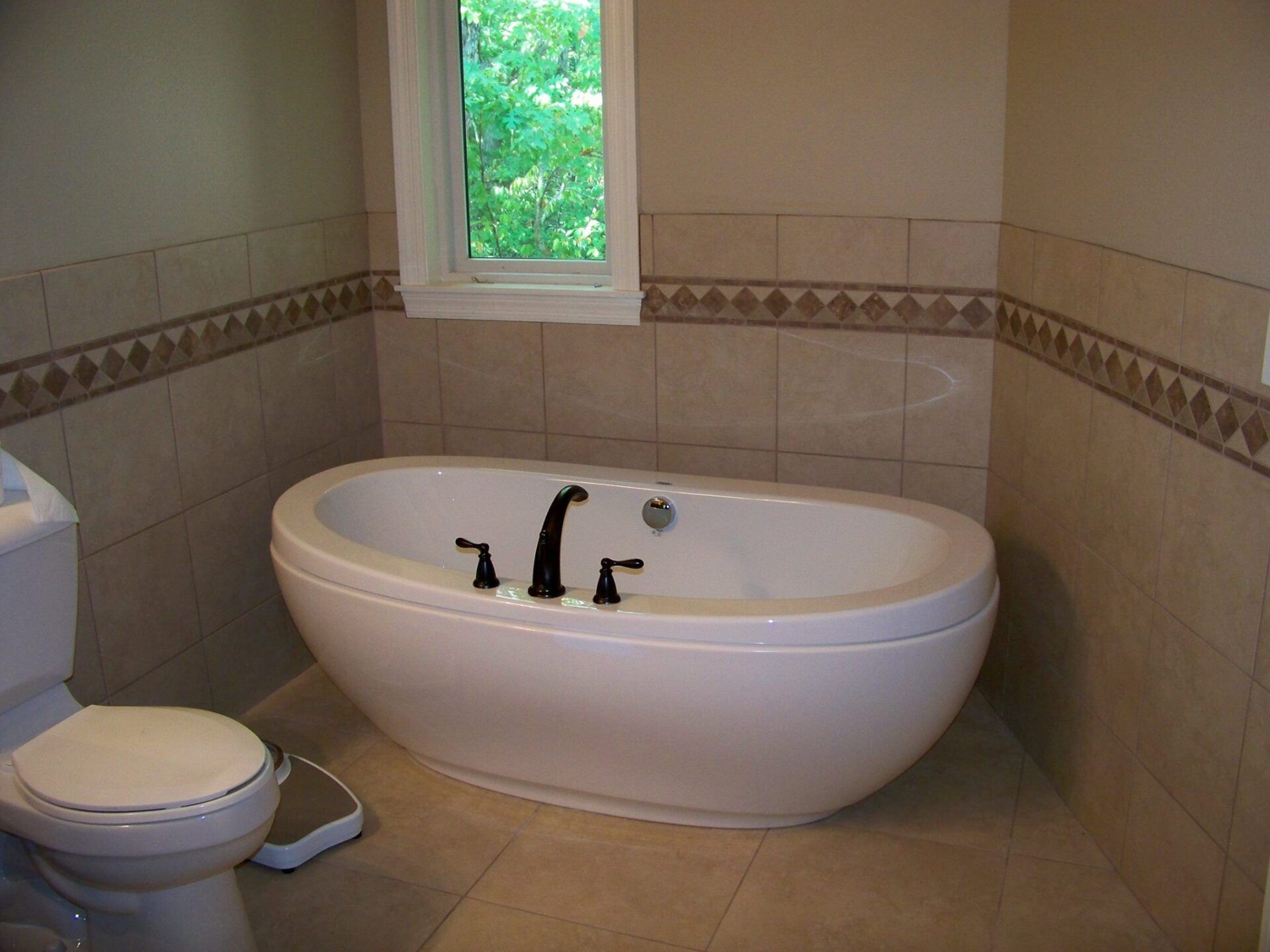 A bathtub in a bathroom next to a toilet