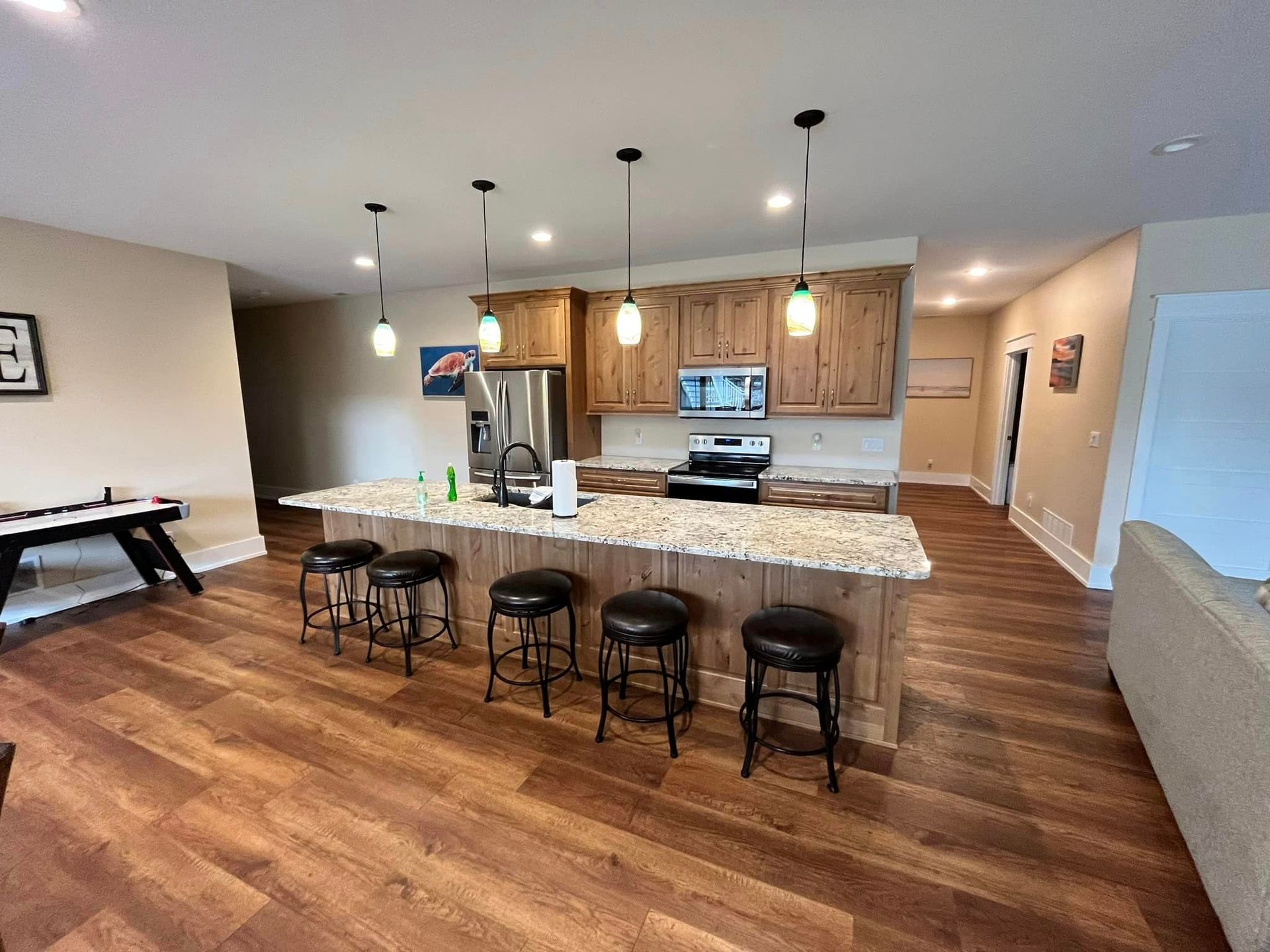 A kitchen with a large island and stools in it