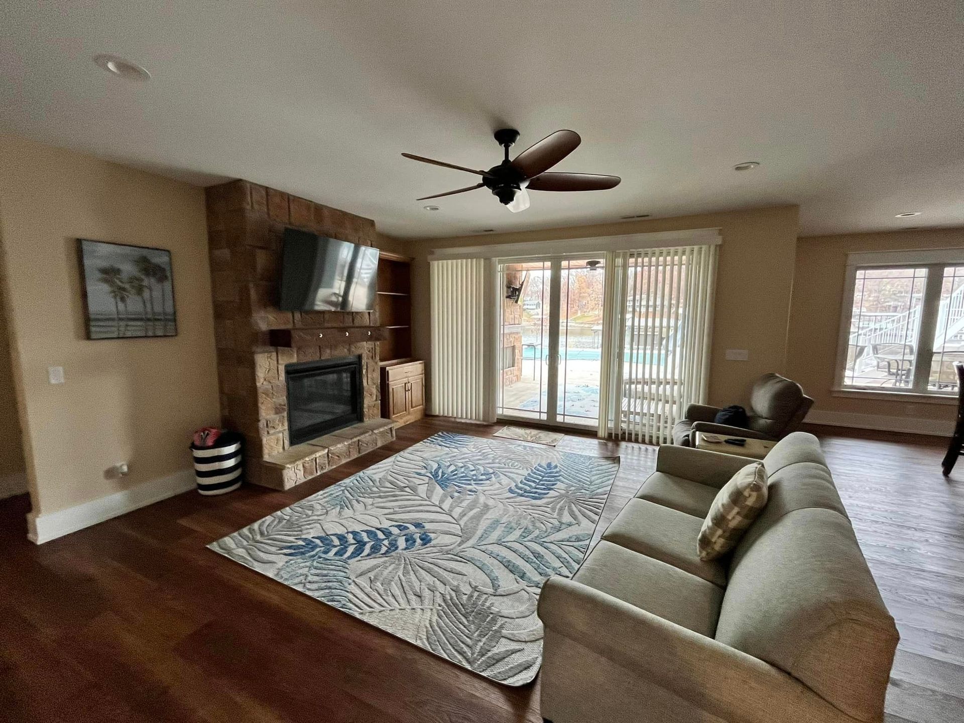 A living room with a couch , fireplace and ceiling fan