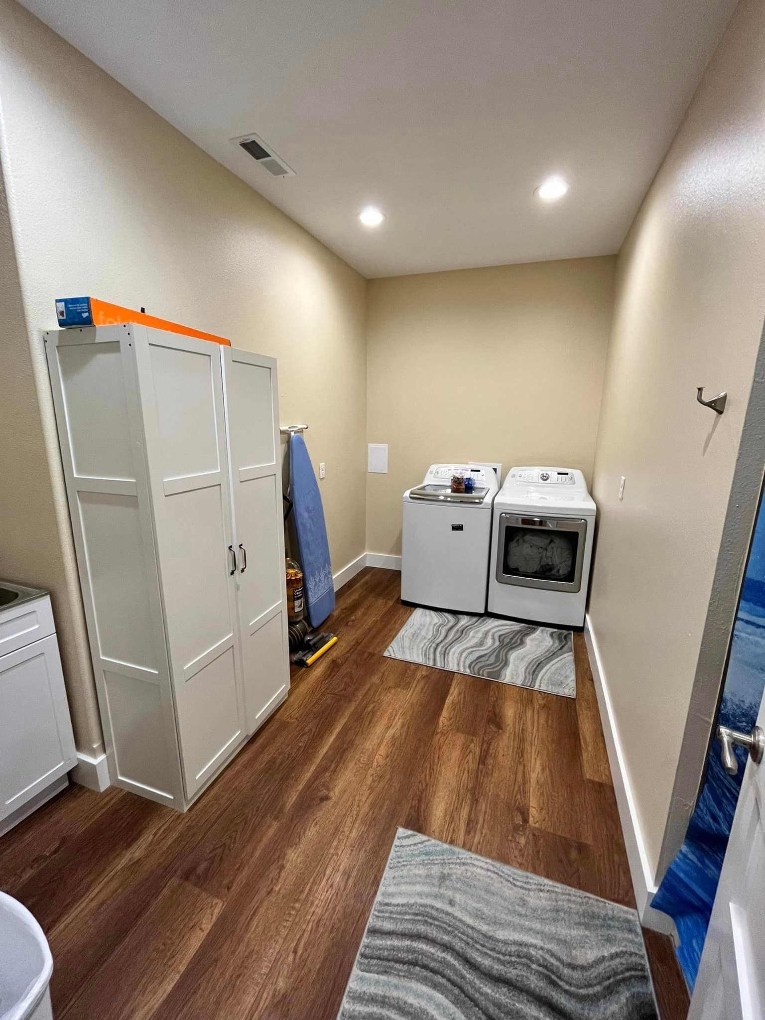 A laundry room with a washer and dryer and a rug.