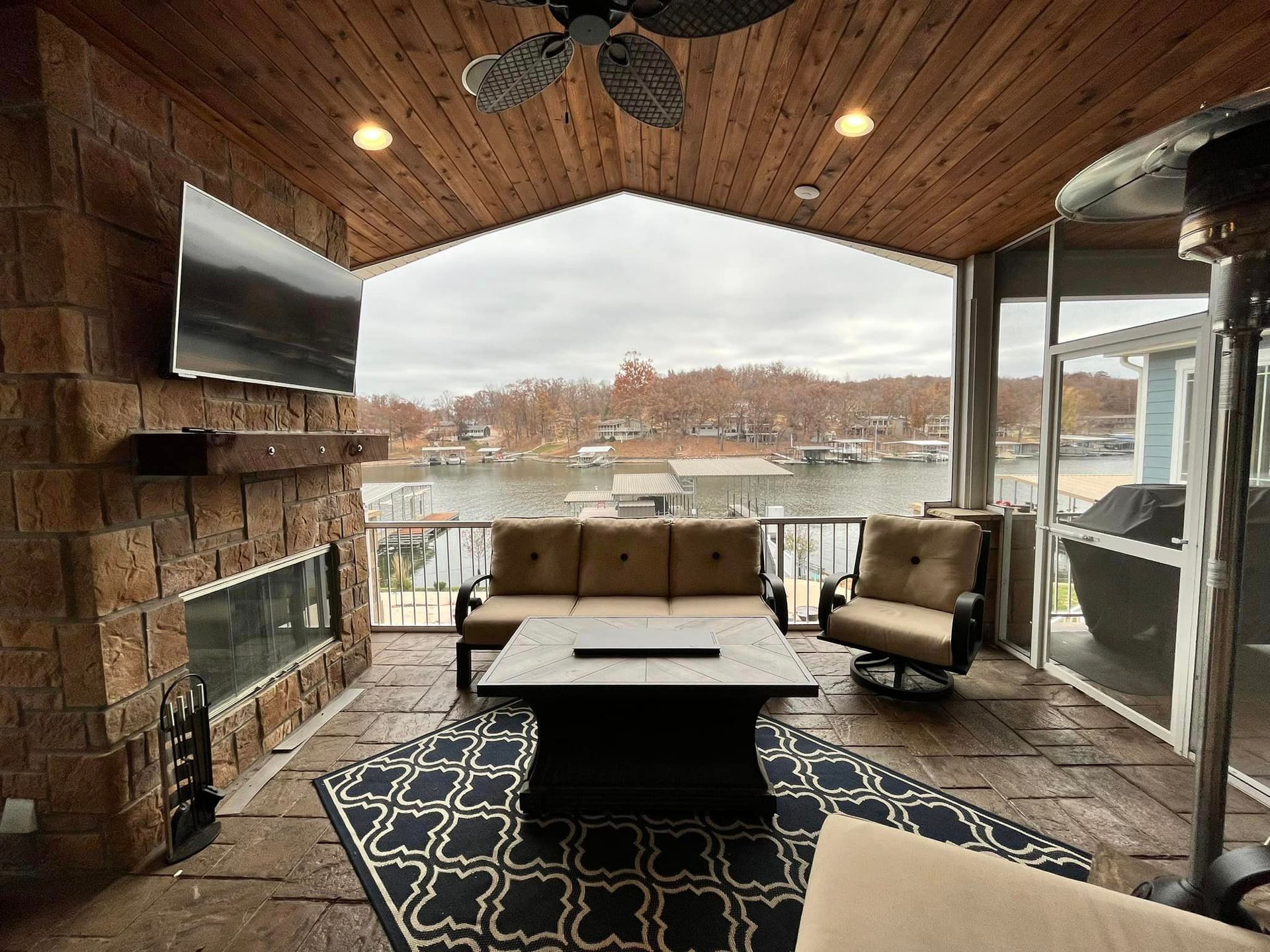 A living room with a couch , chairs , table , fireplace and television.