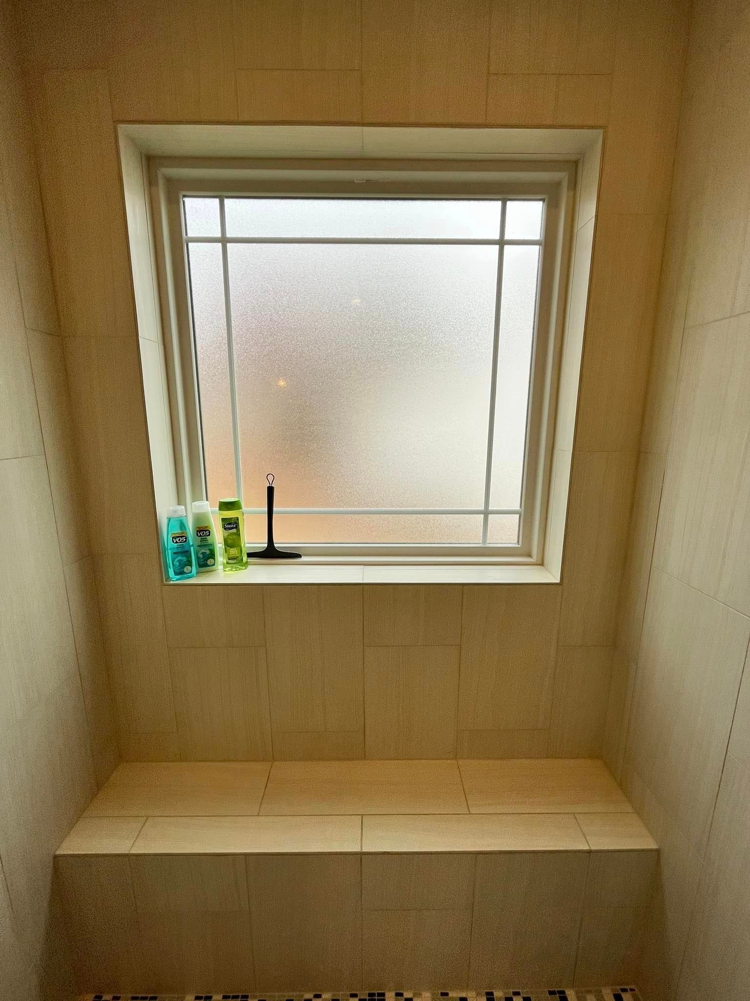 A bathroom with a window and a bench