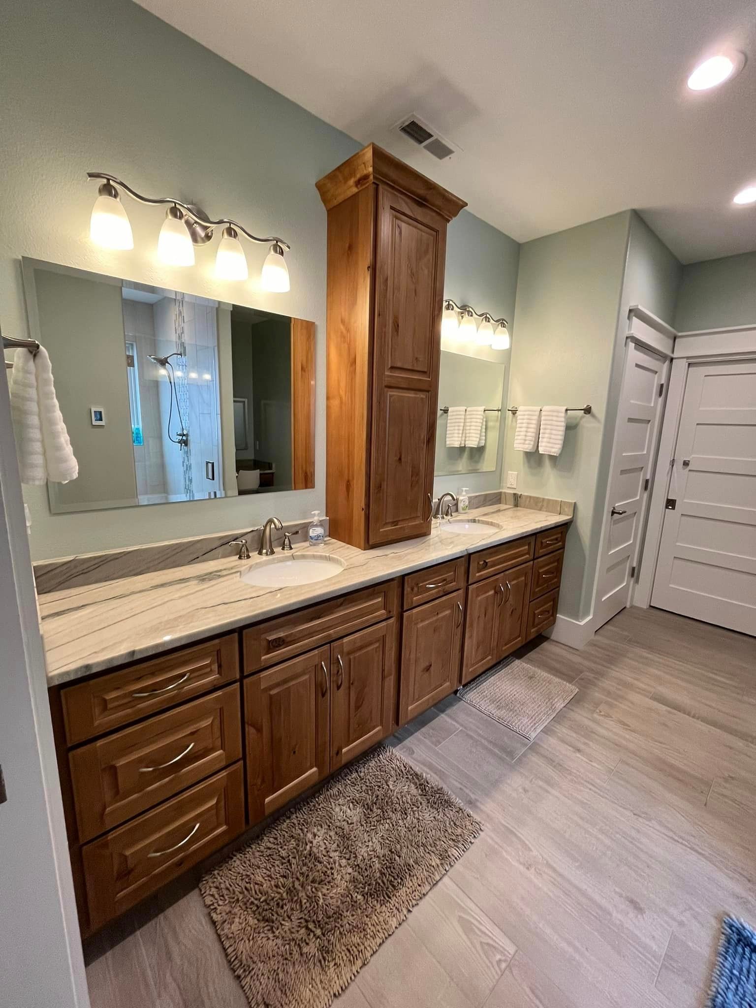A bathroom with two sinks and a large mirror.