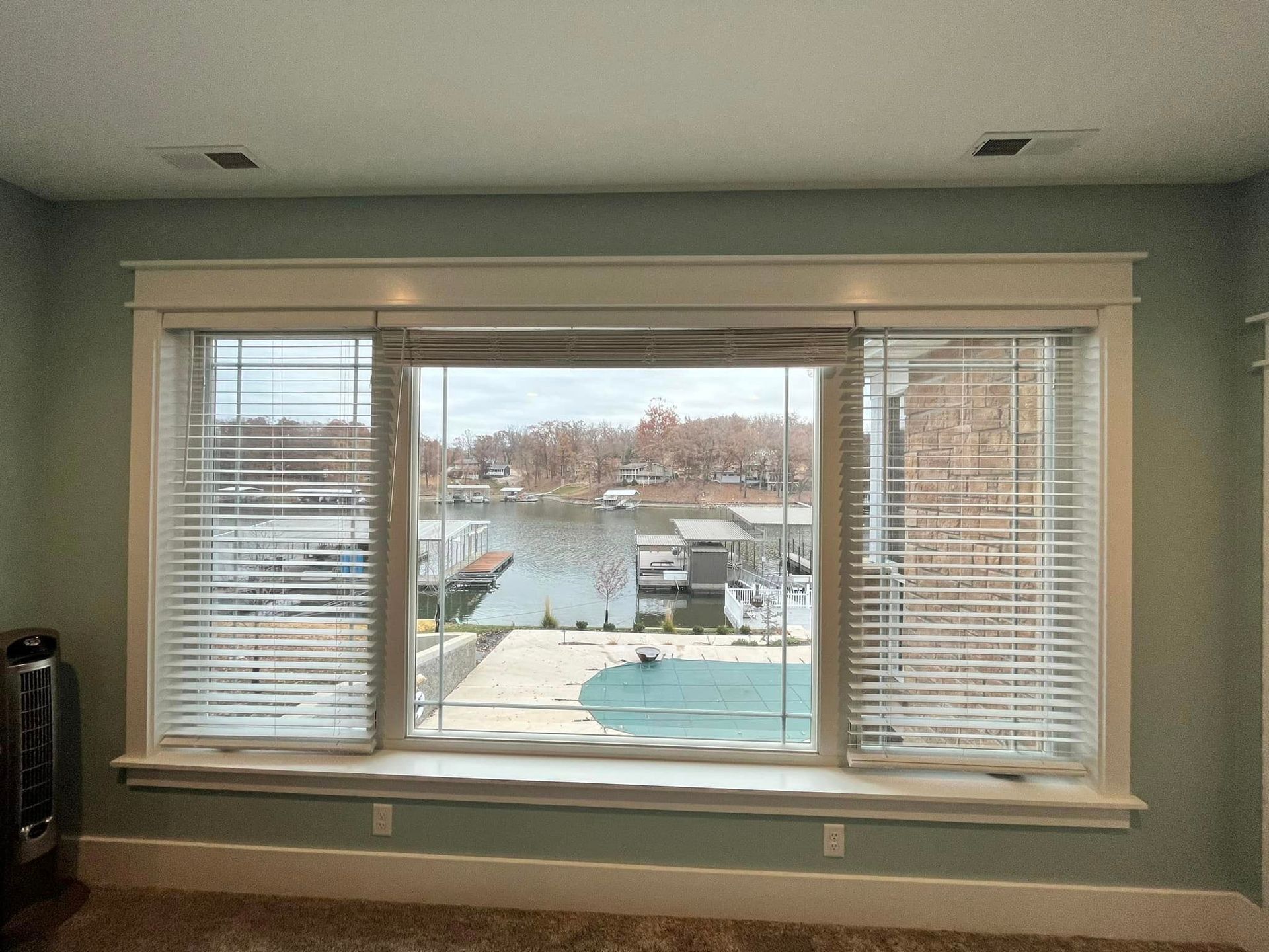 A large window with a view of a lake and a pool