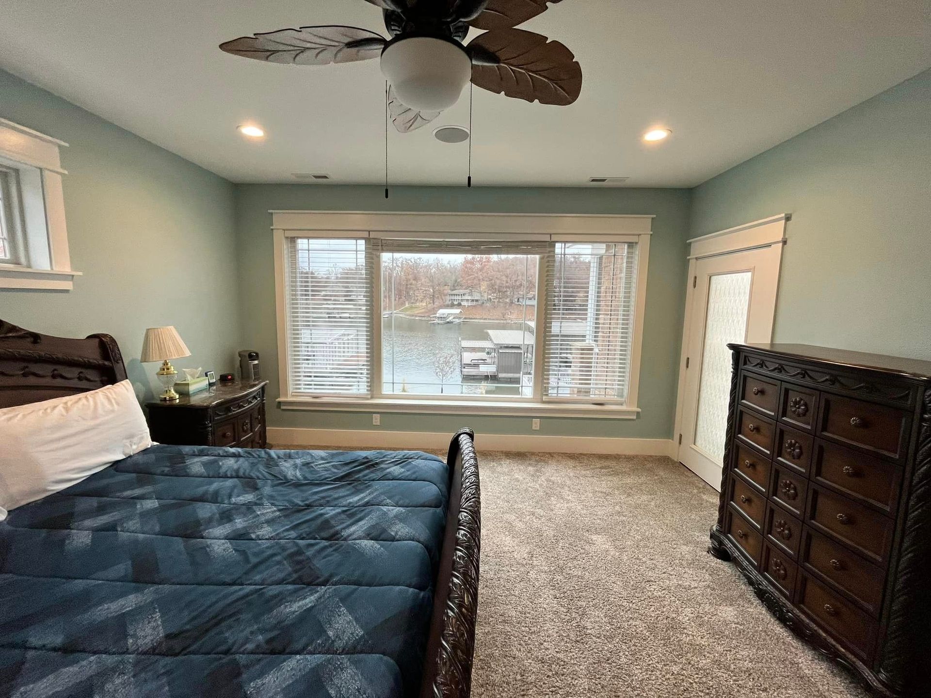 A bedroom with a bed , dresser , and ceiling fan.