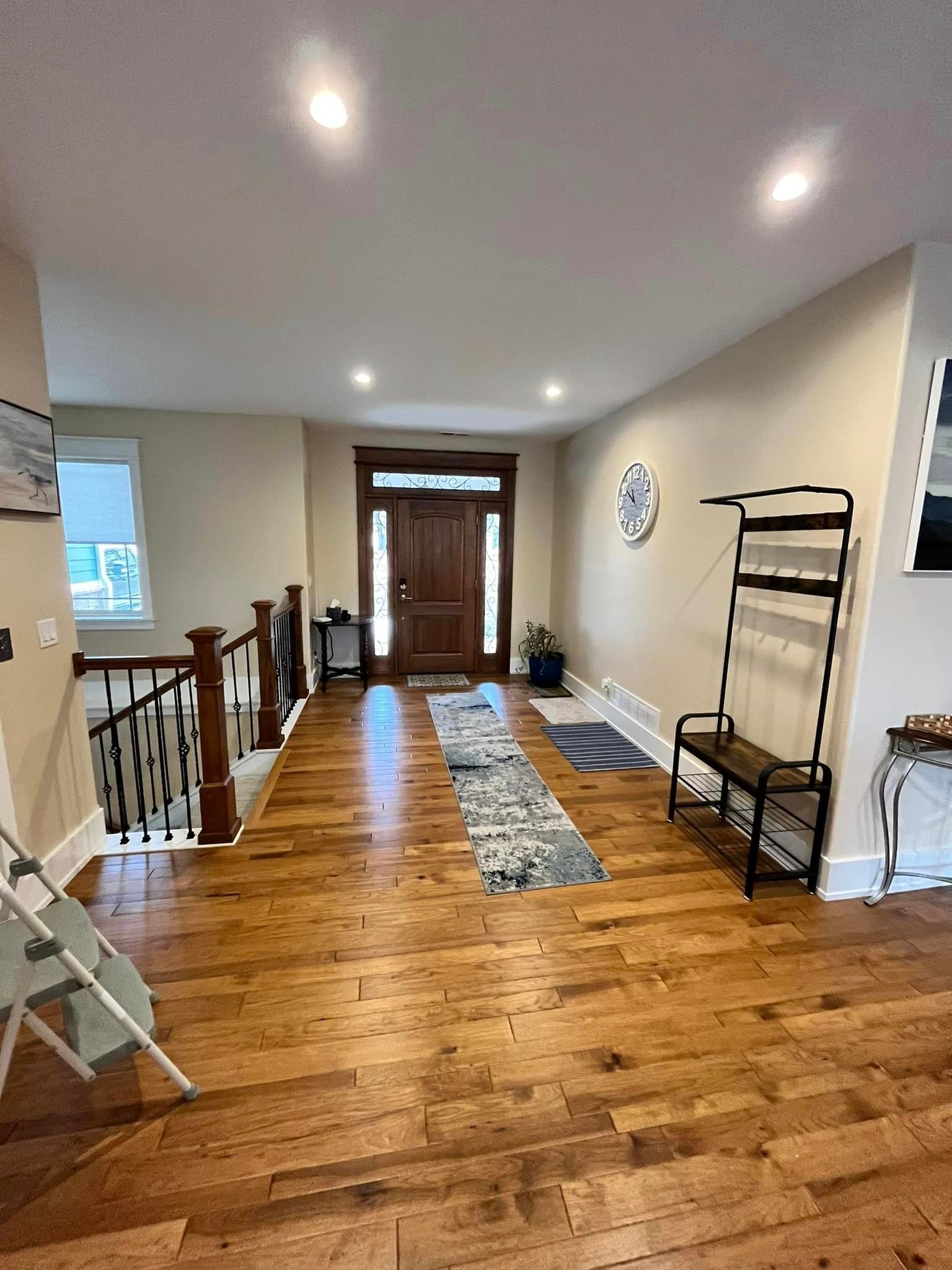 A hallway with hardwood floors and stairs in a house.
