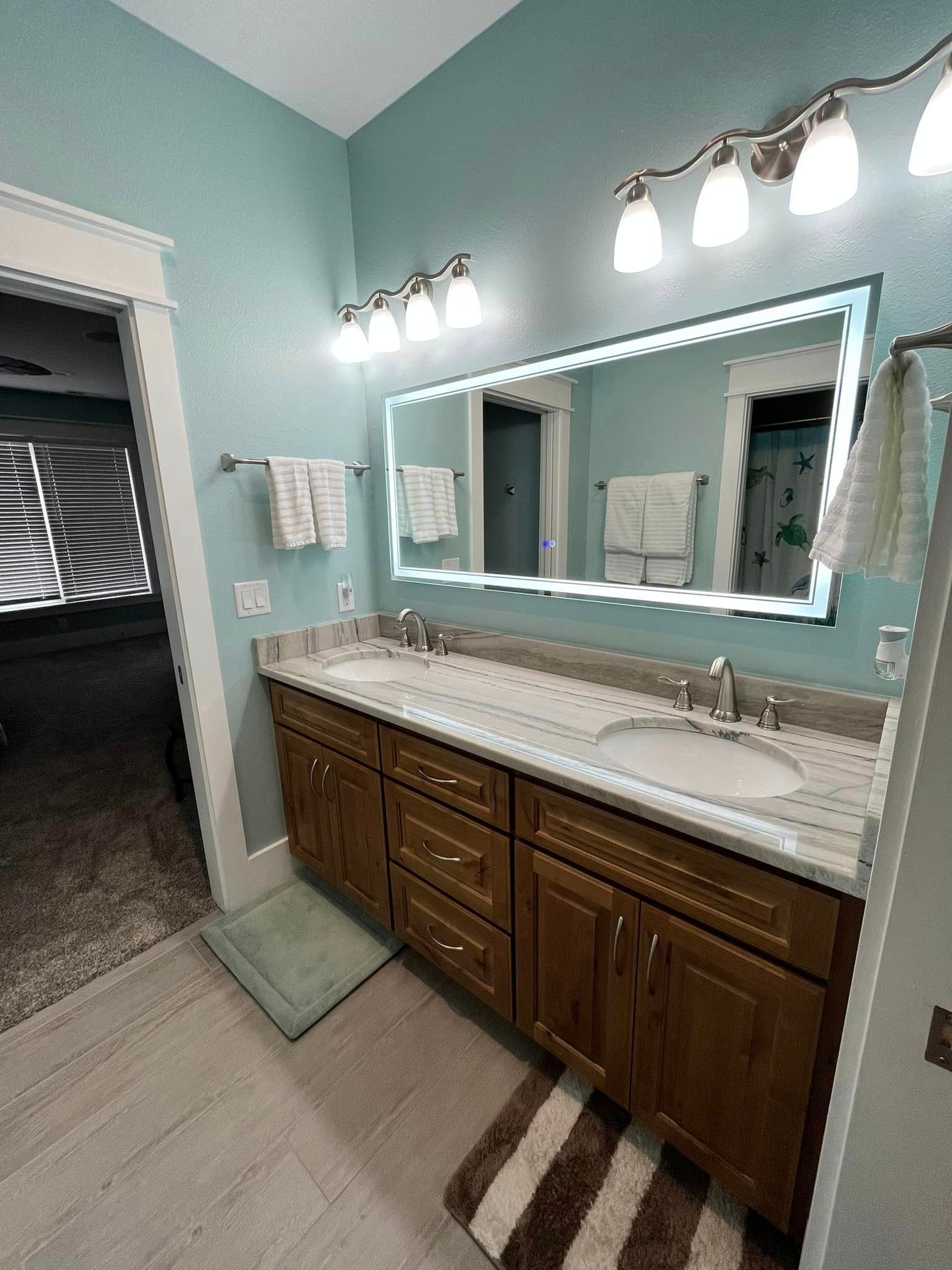 A bathroom with two sinks and a large mirror.