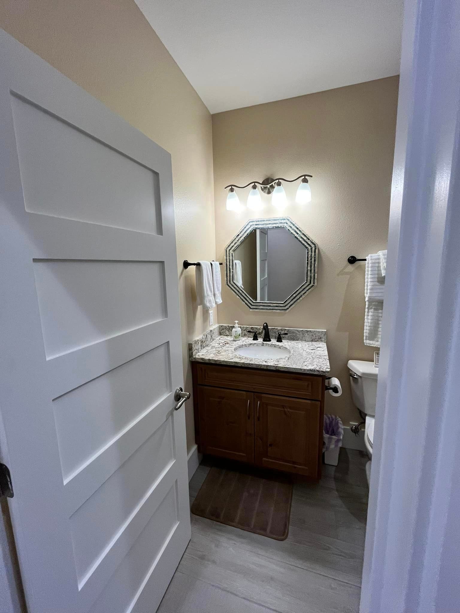 A bathroom with a sink , toilet and mirror.