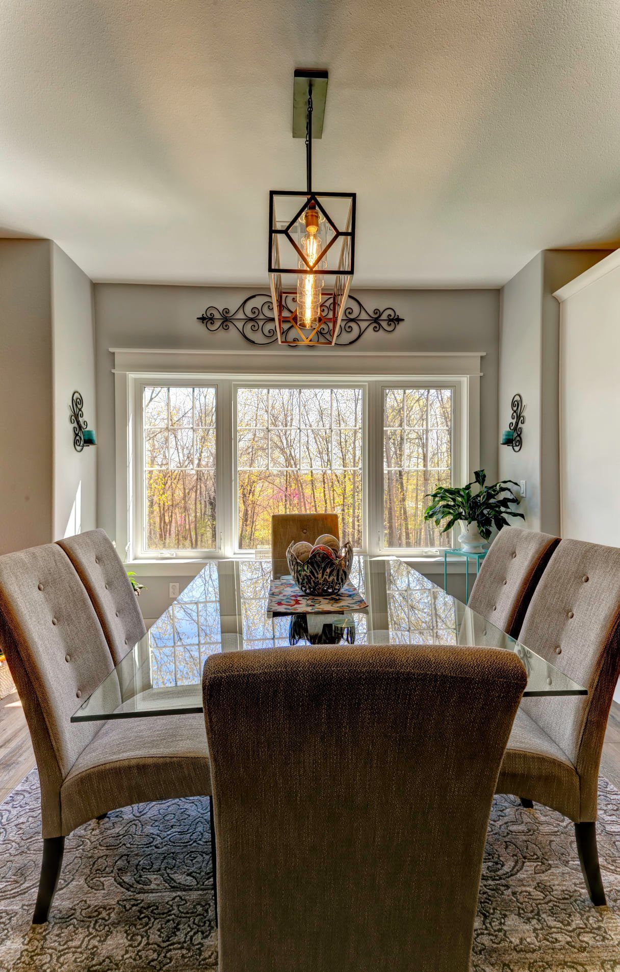 A dining room with a table and chairs and a chandelier hanging from the ceiling.