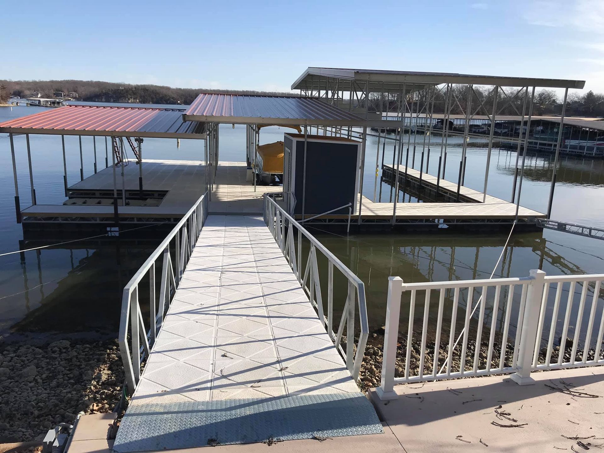 A dock on a lake with a white railing
