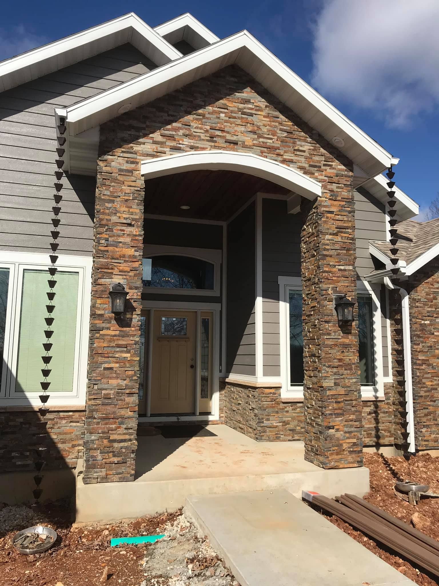 The front of a house with a stone facade and a wooden door.