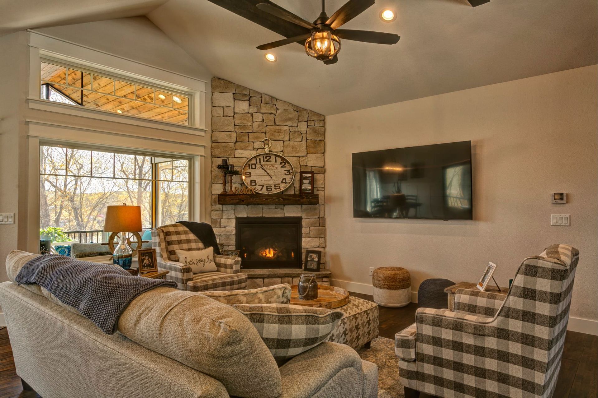 A living room with a couch , chairs , a fireplace and a flat screen tv.