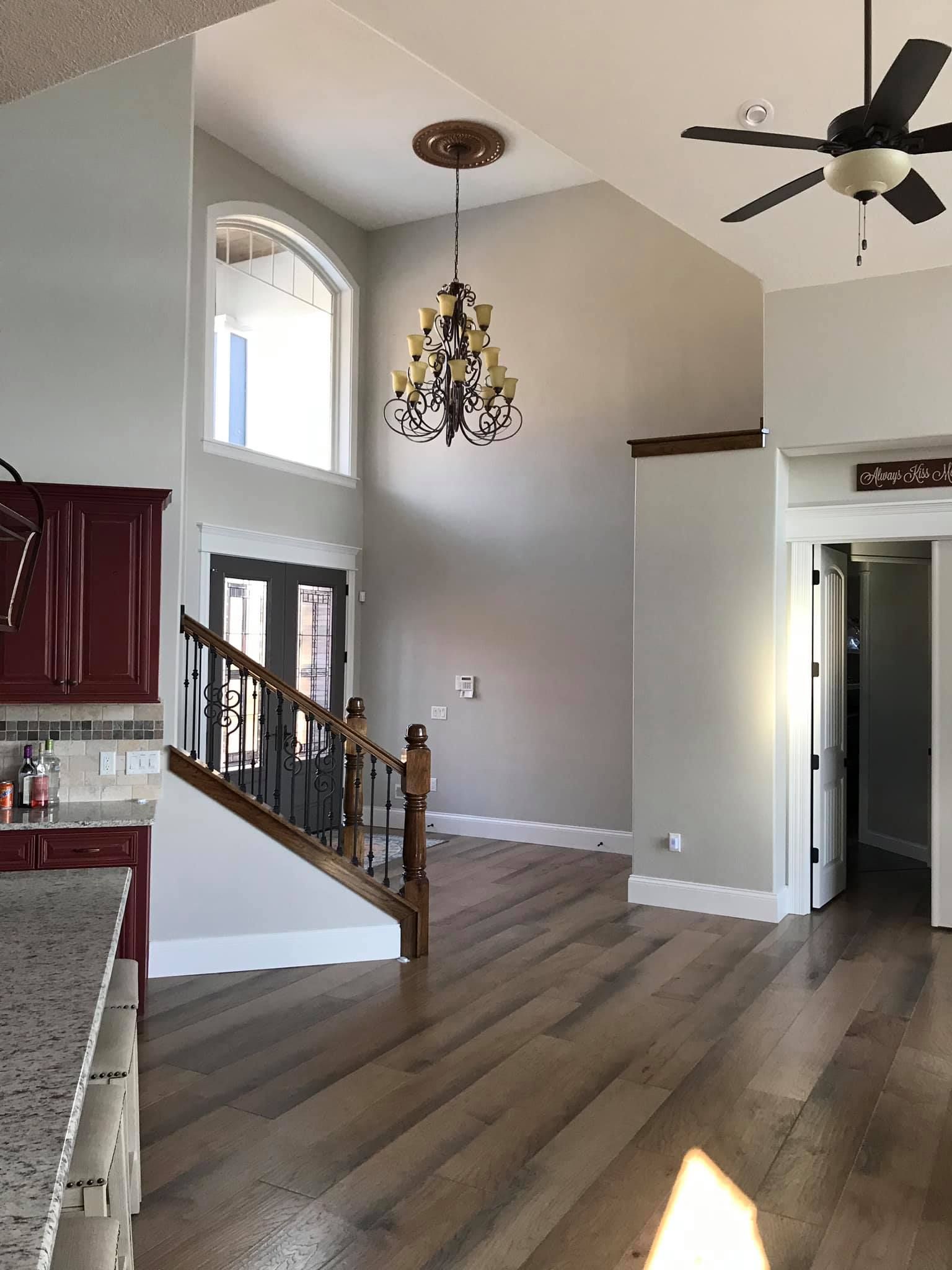 A kitchen with a staircase and a chandelier hanging from the ceiling.