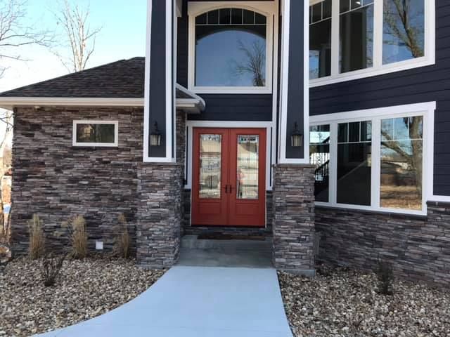 A large house with a red door and a walkway leading to it.