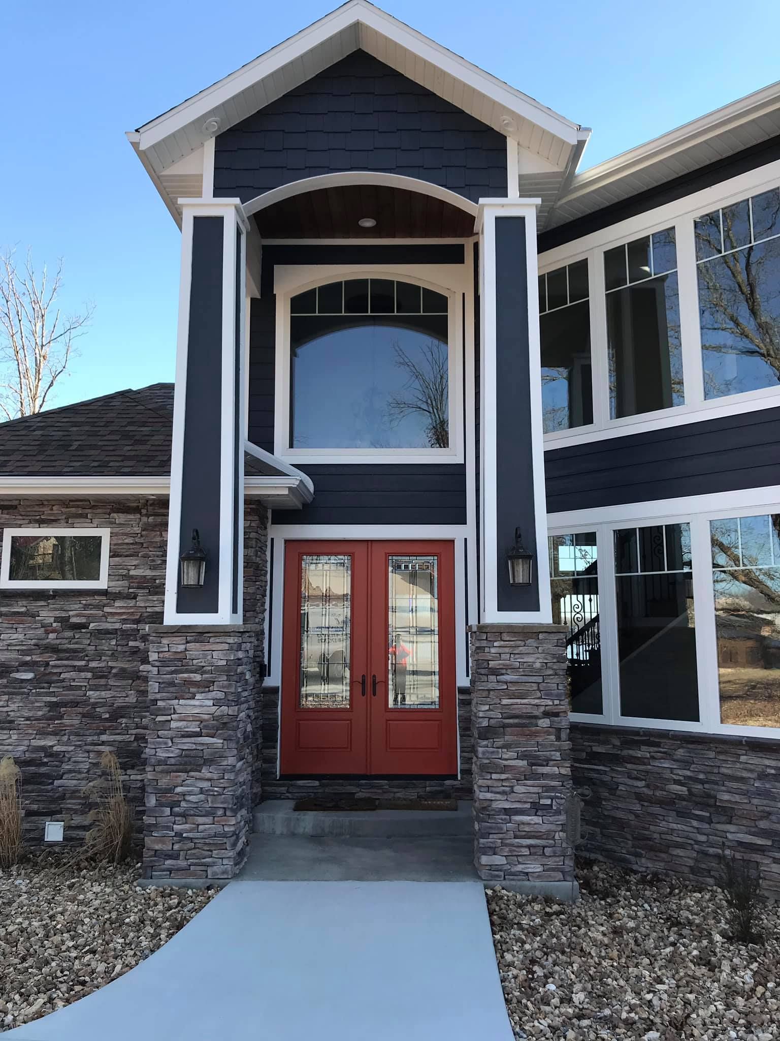 A large house with a red door and many windows