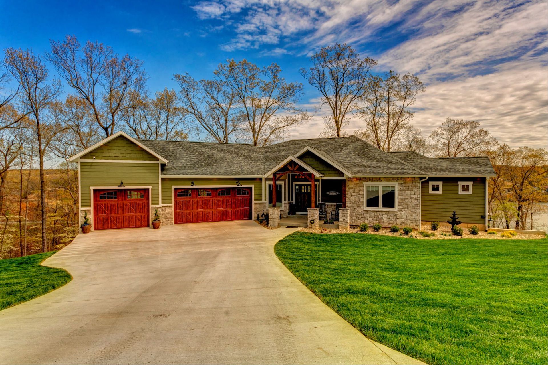 A large house with two garages and a driveway leading to it.