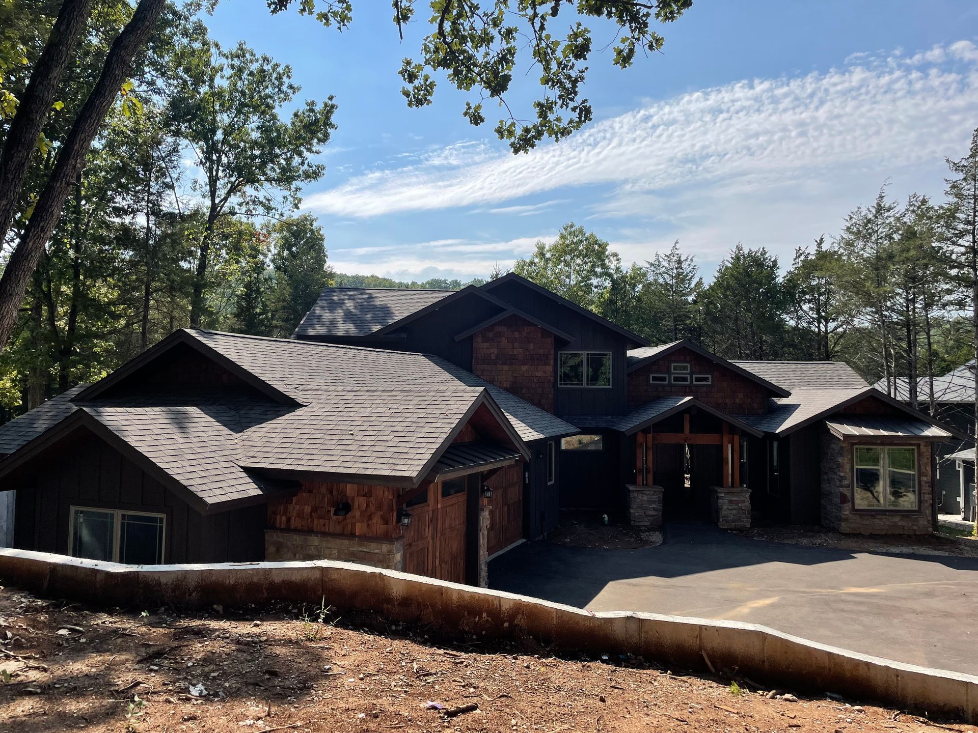 A large house is sitting on top of a hill surrounded by trees.