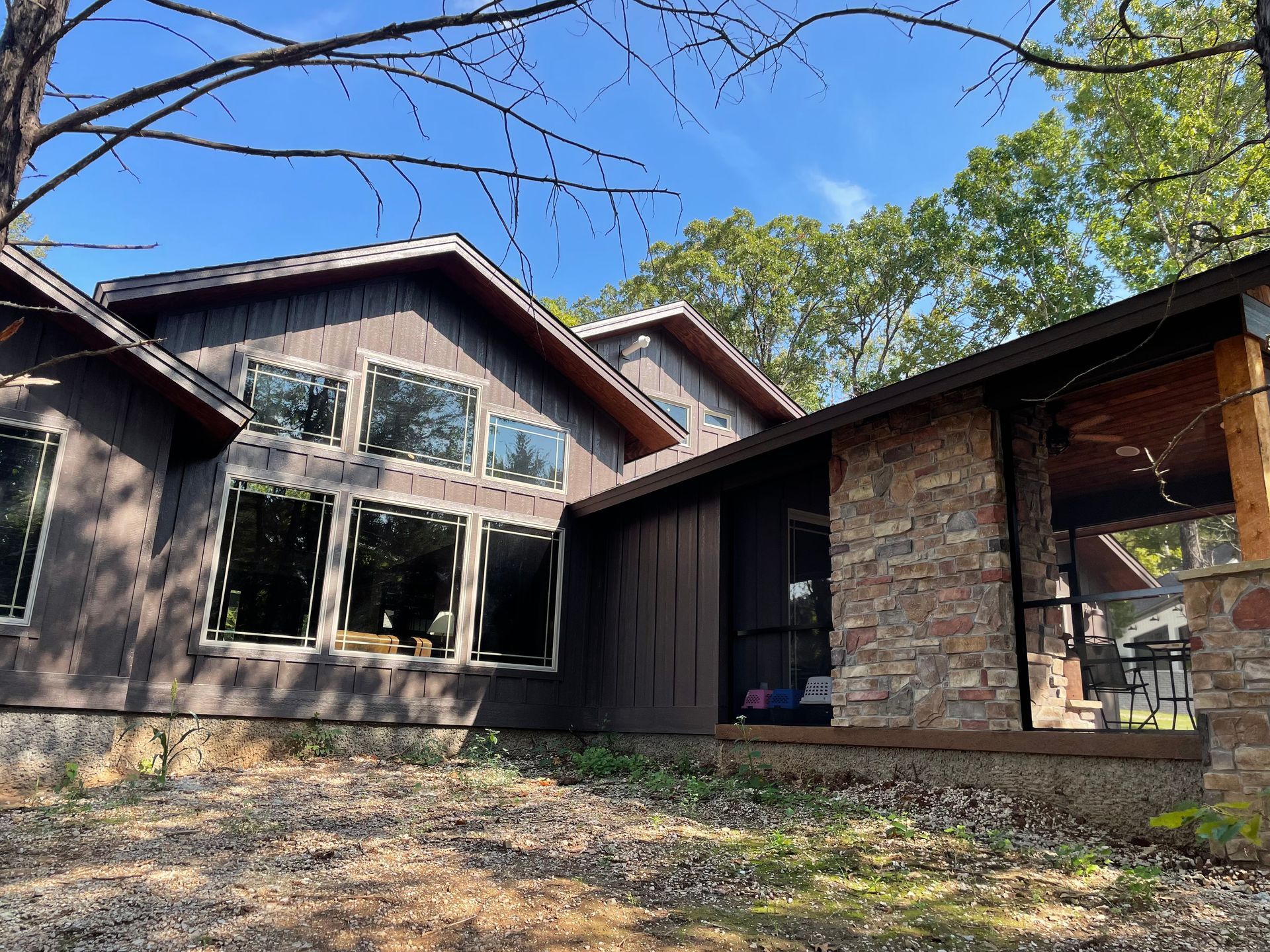 A large house with a lot of windows is surrounded by trees.