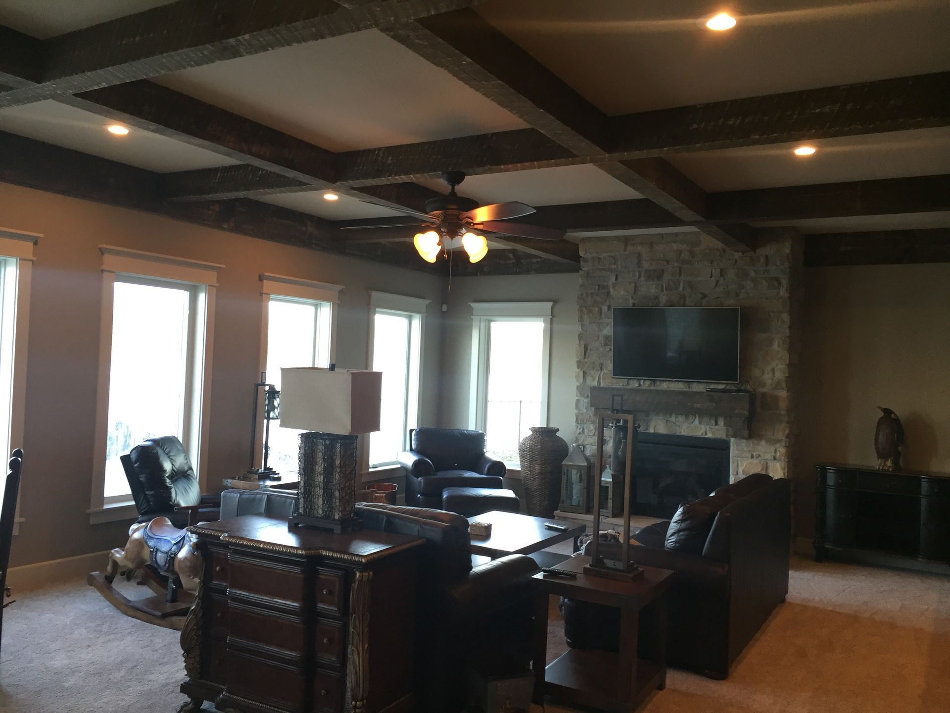 A living room with a fireplace and a ceiling fan