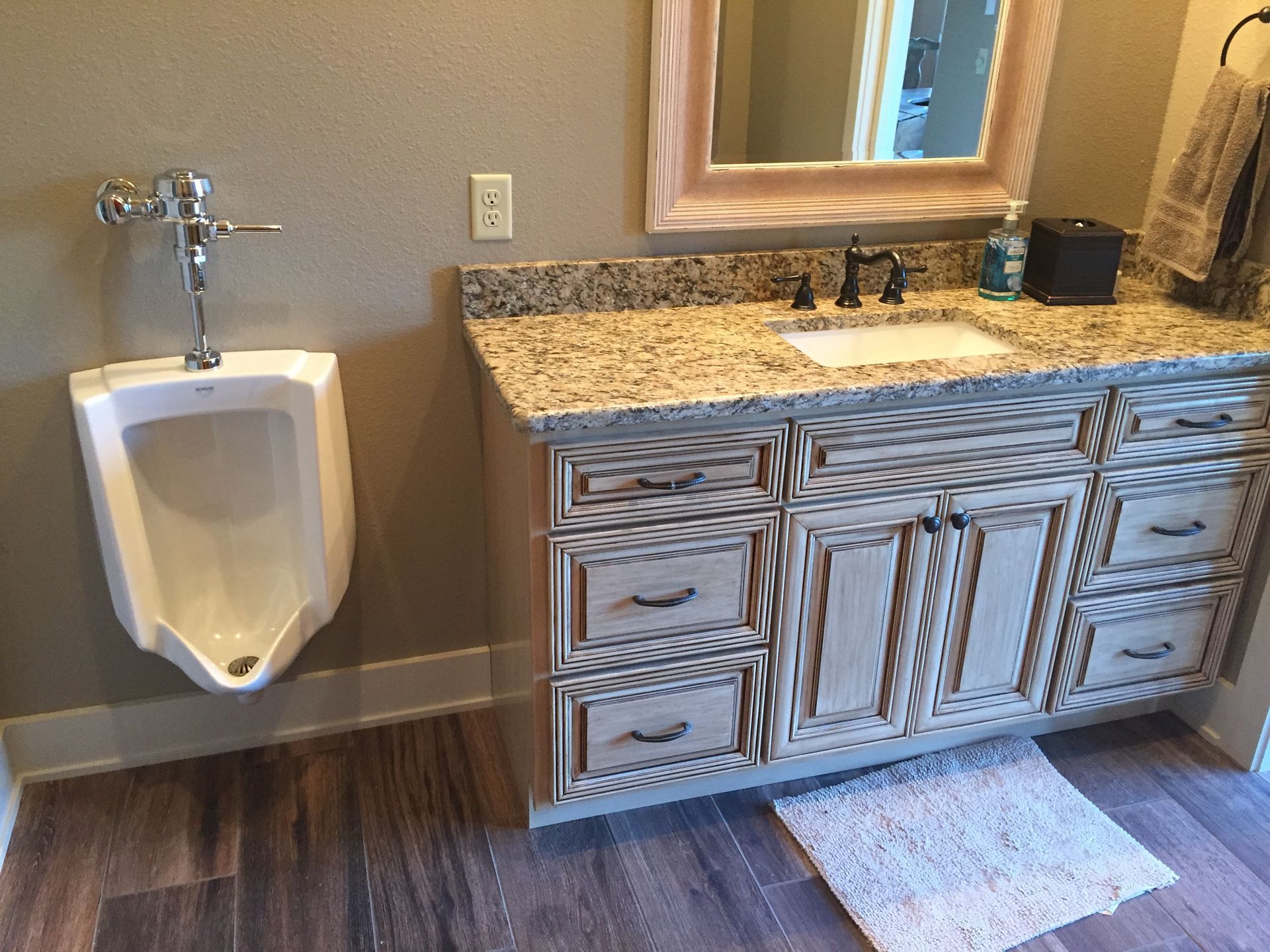 A bathroom with a urinal and a sink