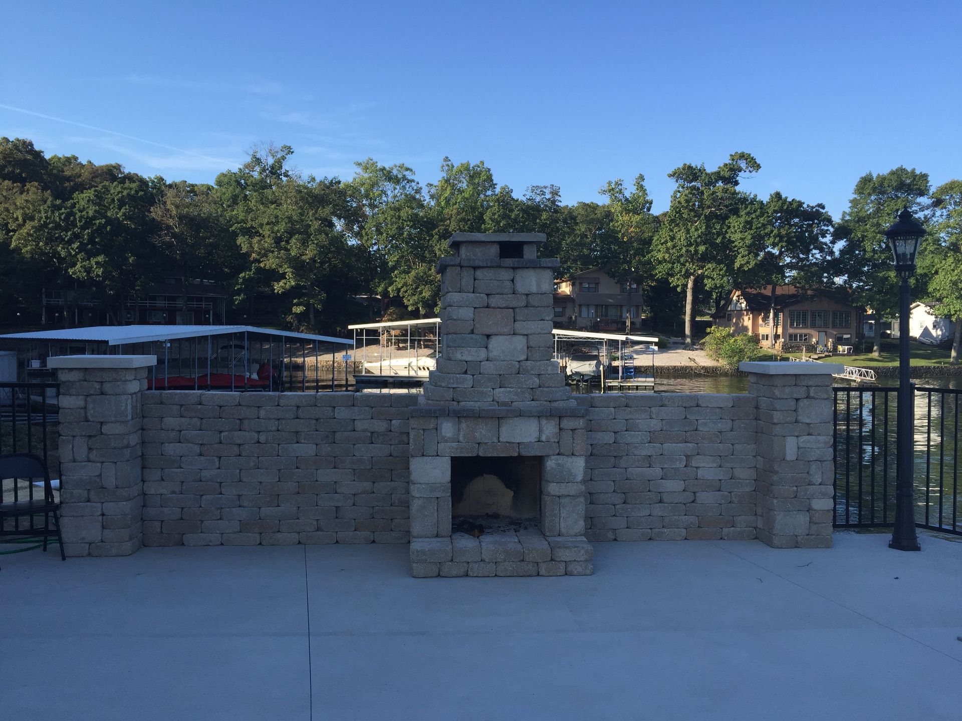 A brick fireplace with a view of a lake