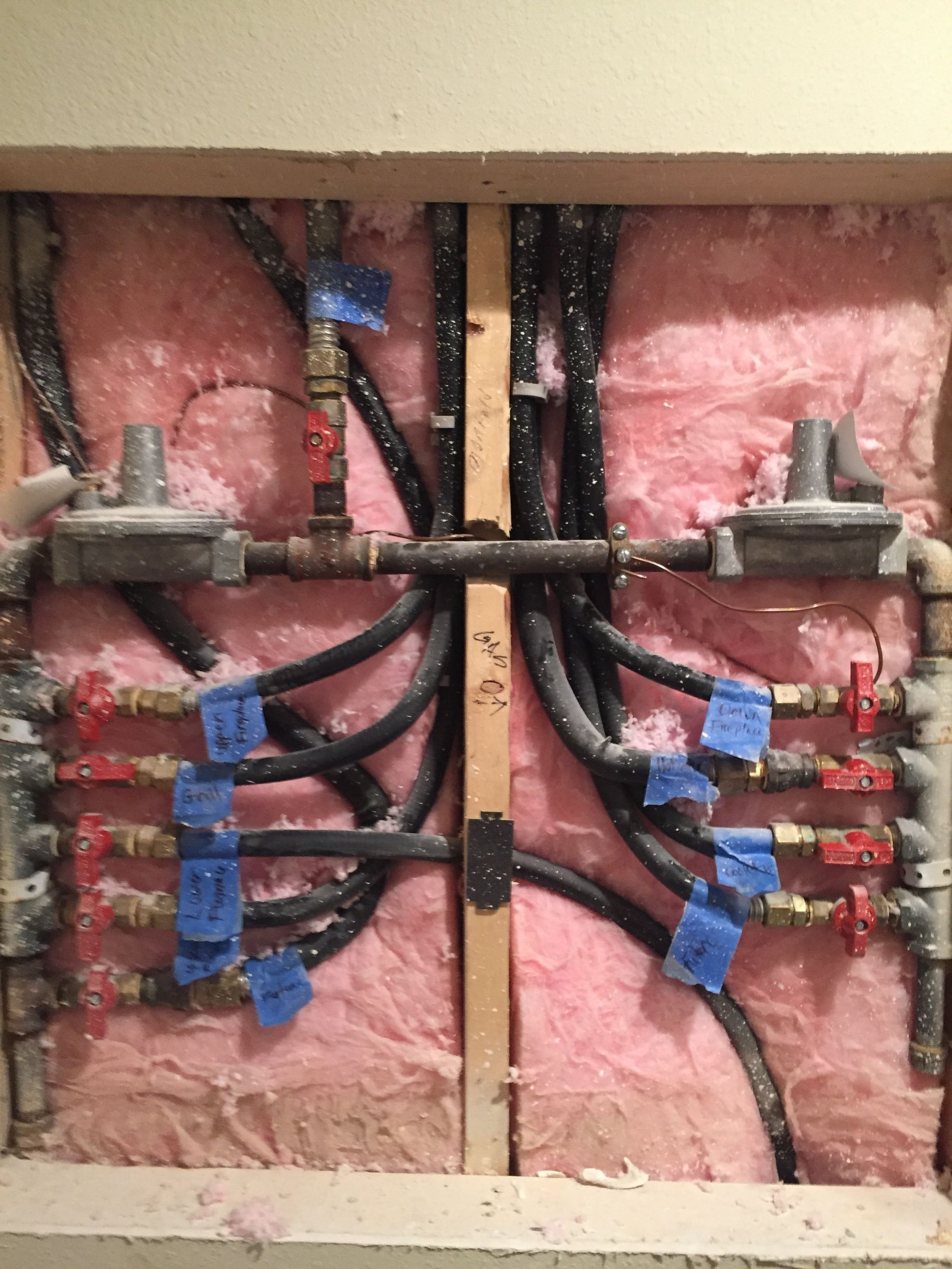 A bunch of pipes are connected to a wall.