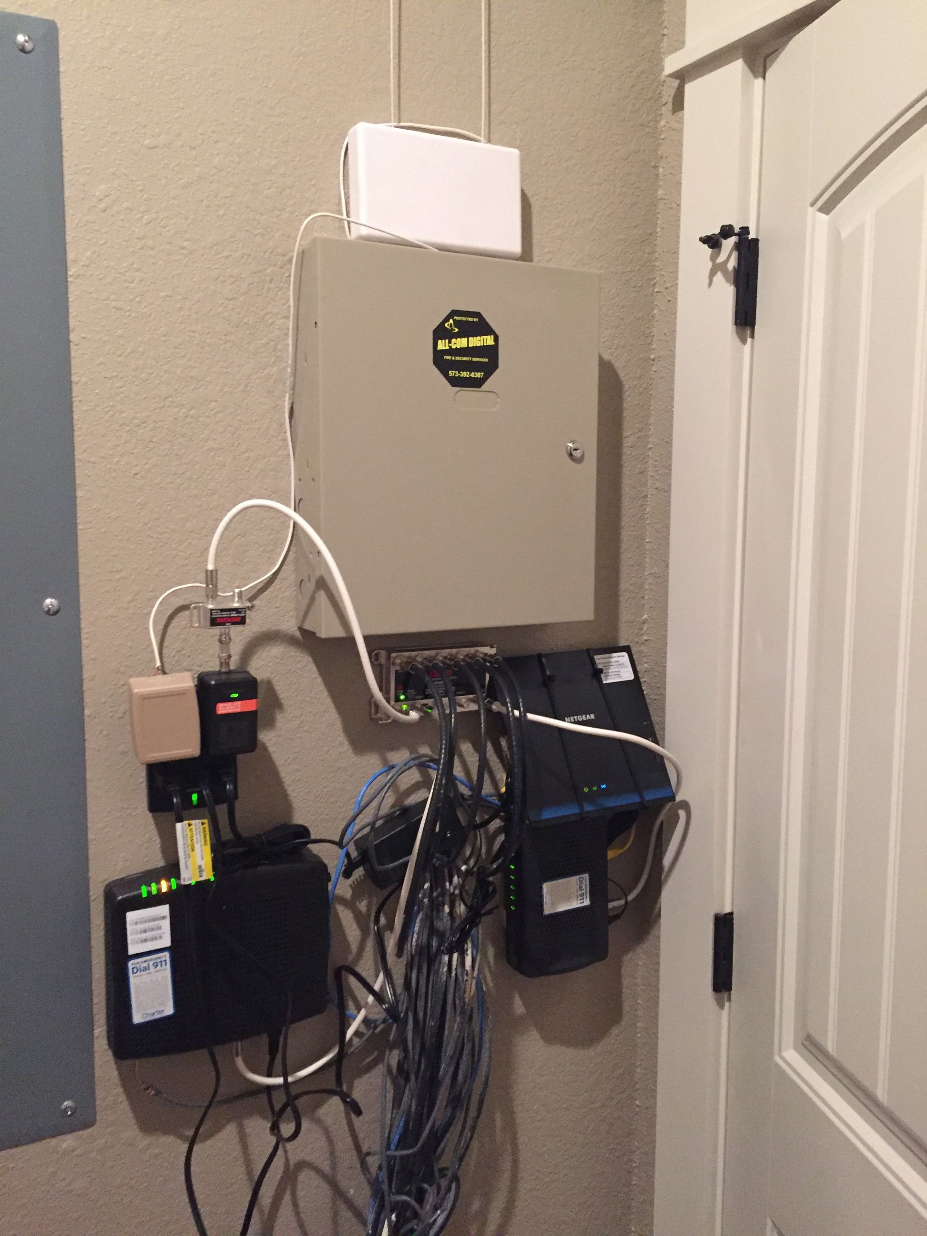 A bunch of wires are hanging on a wall next to a door.