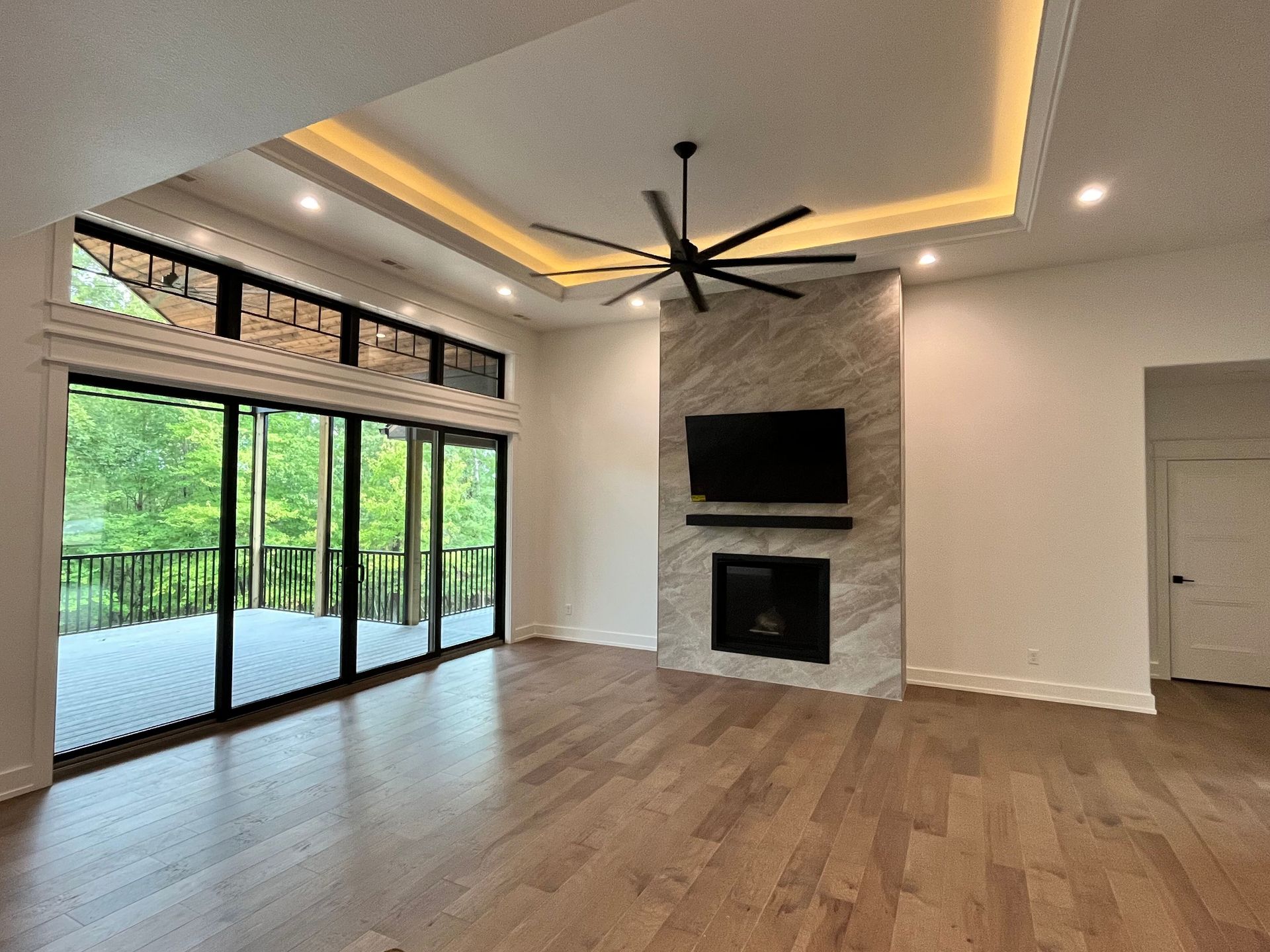 A living room with hardwood floors , a fireplace and a flat screen tv.