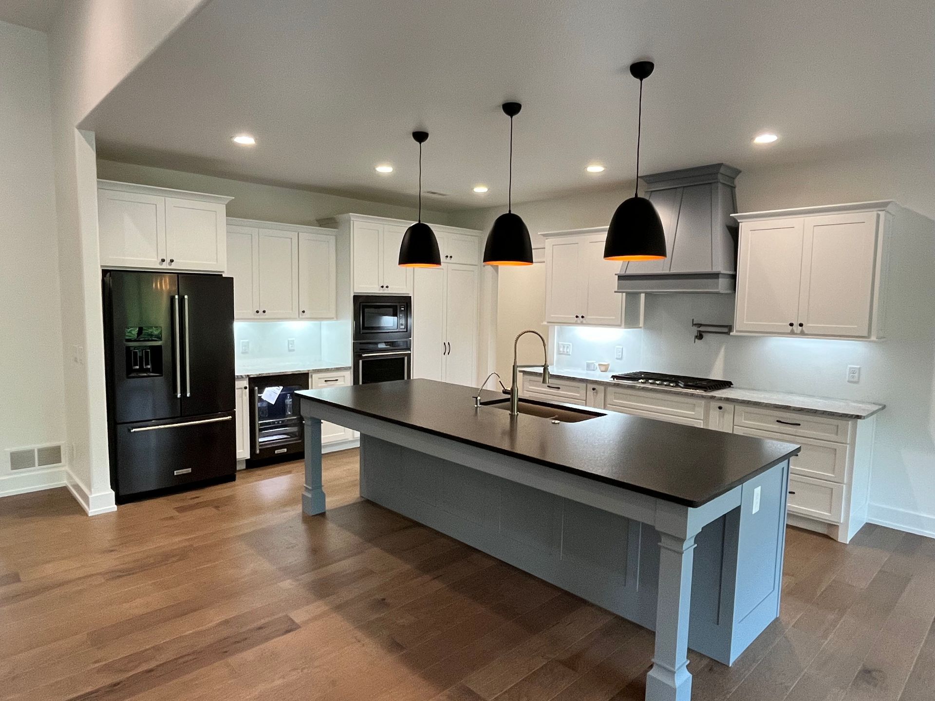 A kitchen with a large island and white cabinets