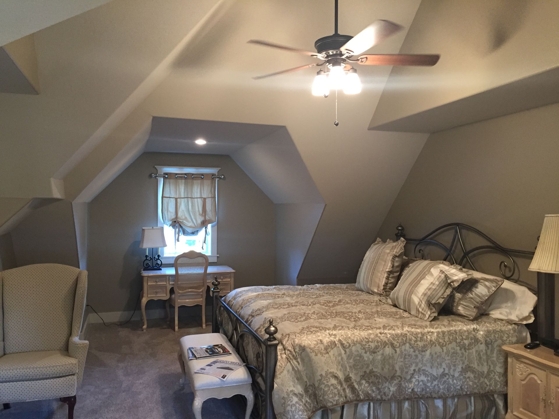 A bedroom with two beds and a ceiling fan