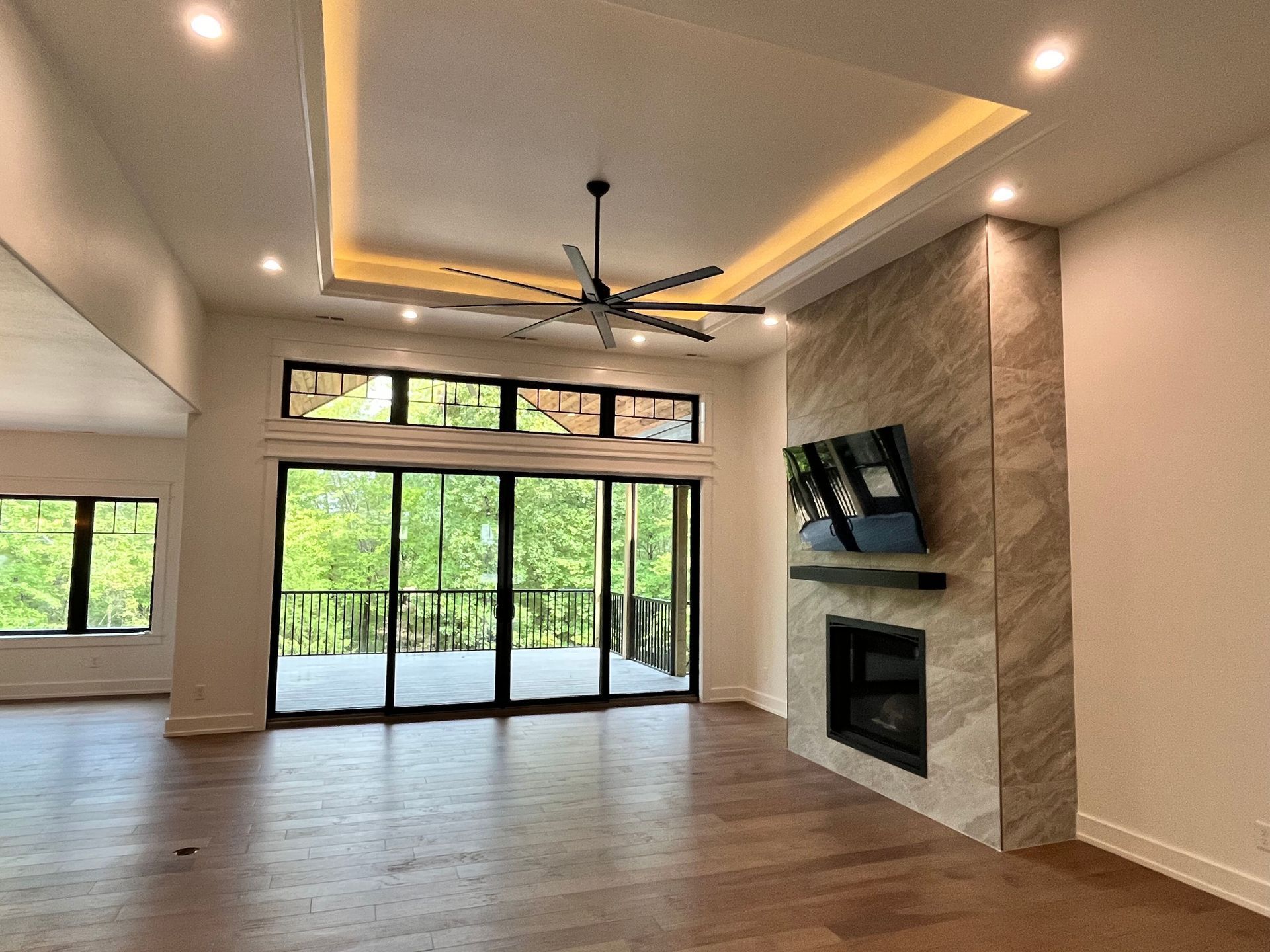 An empty living room with a fireplace and sliding glass doors