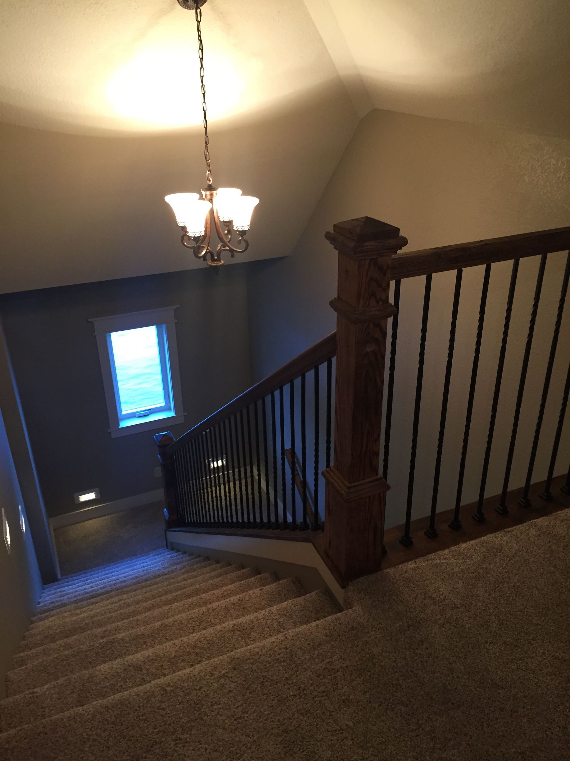 A staircase with a chandelier hanging from the ceiling
