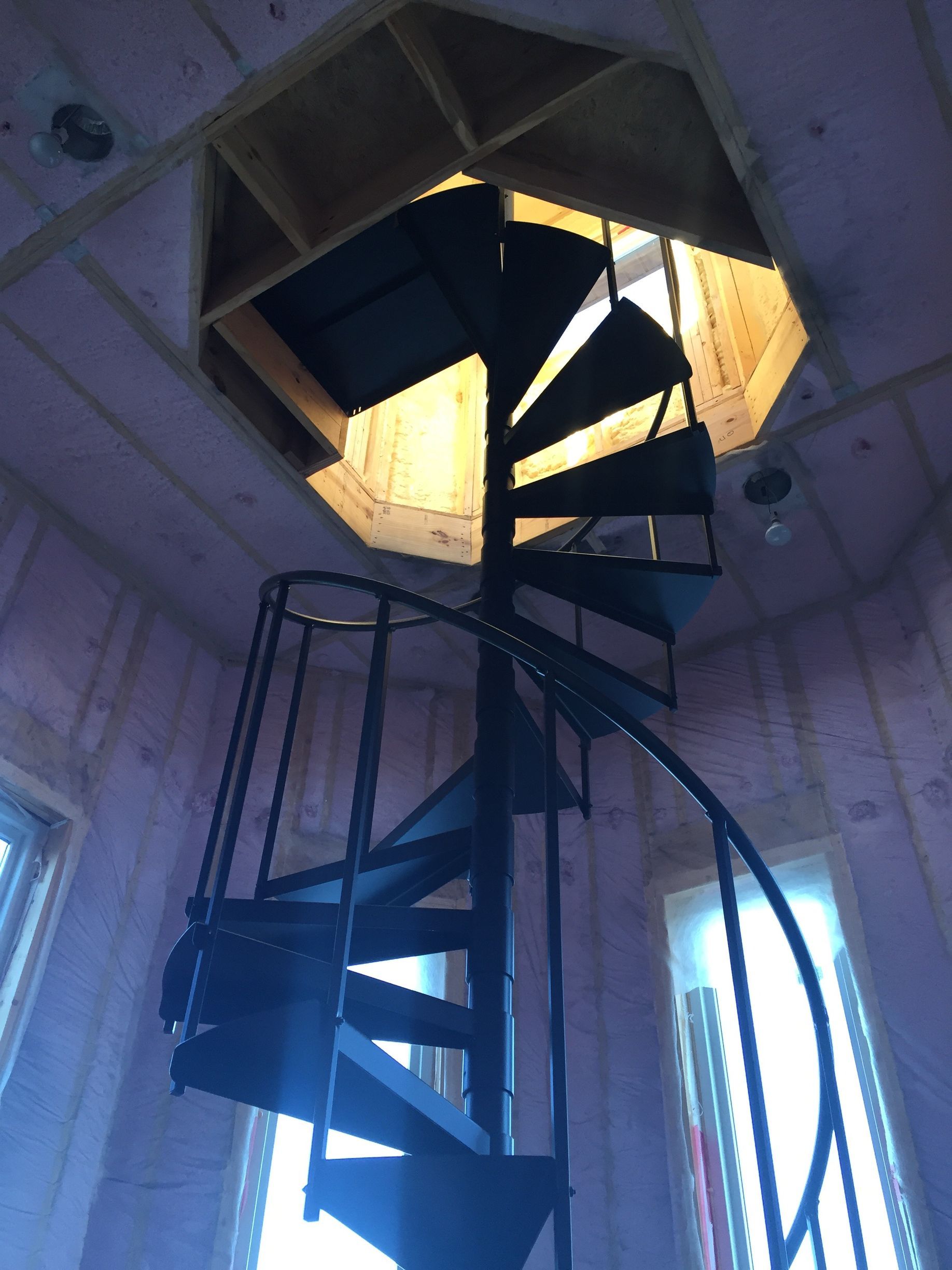 A spiral staircase going up to the ceiling of a building