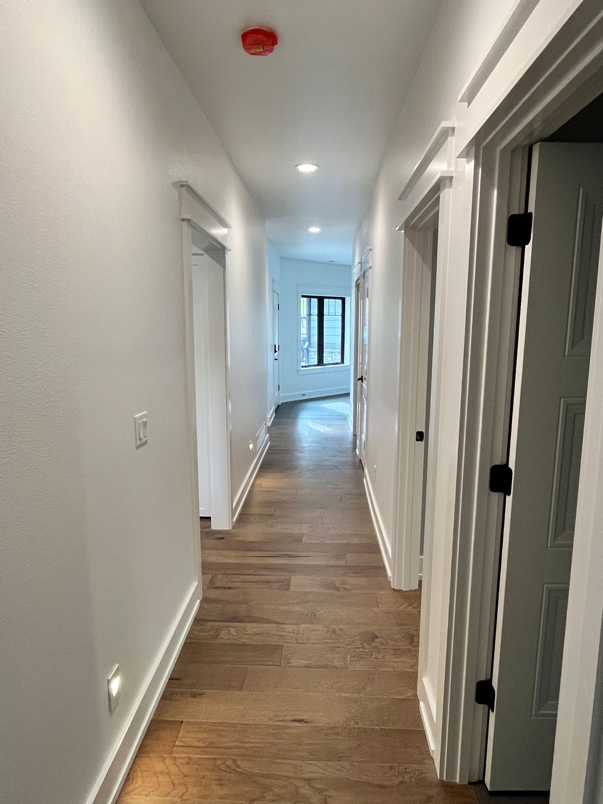 A long hallway with wooden floors and white walls