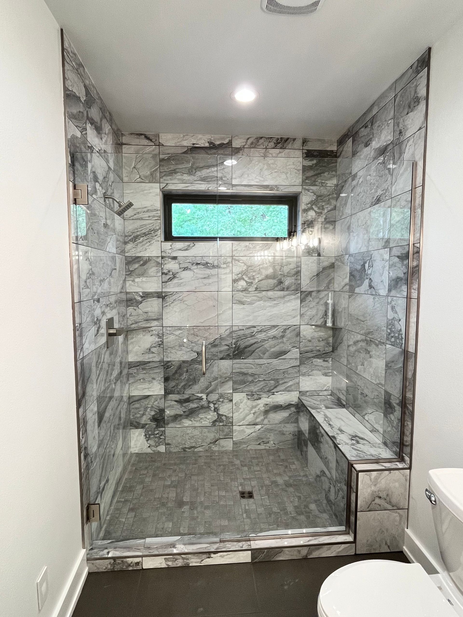 A bathroom with a walk in shower and a toilet.