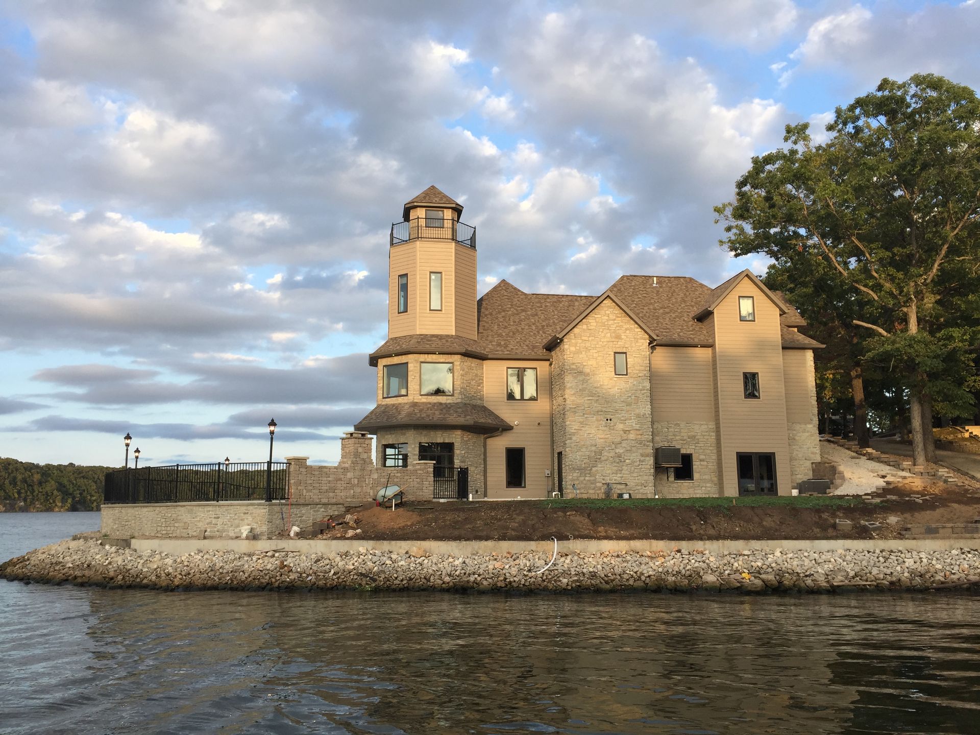 A large house sits on the shore of a lake
