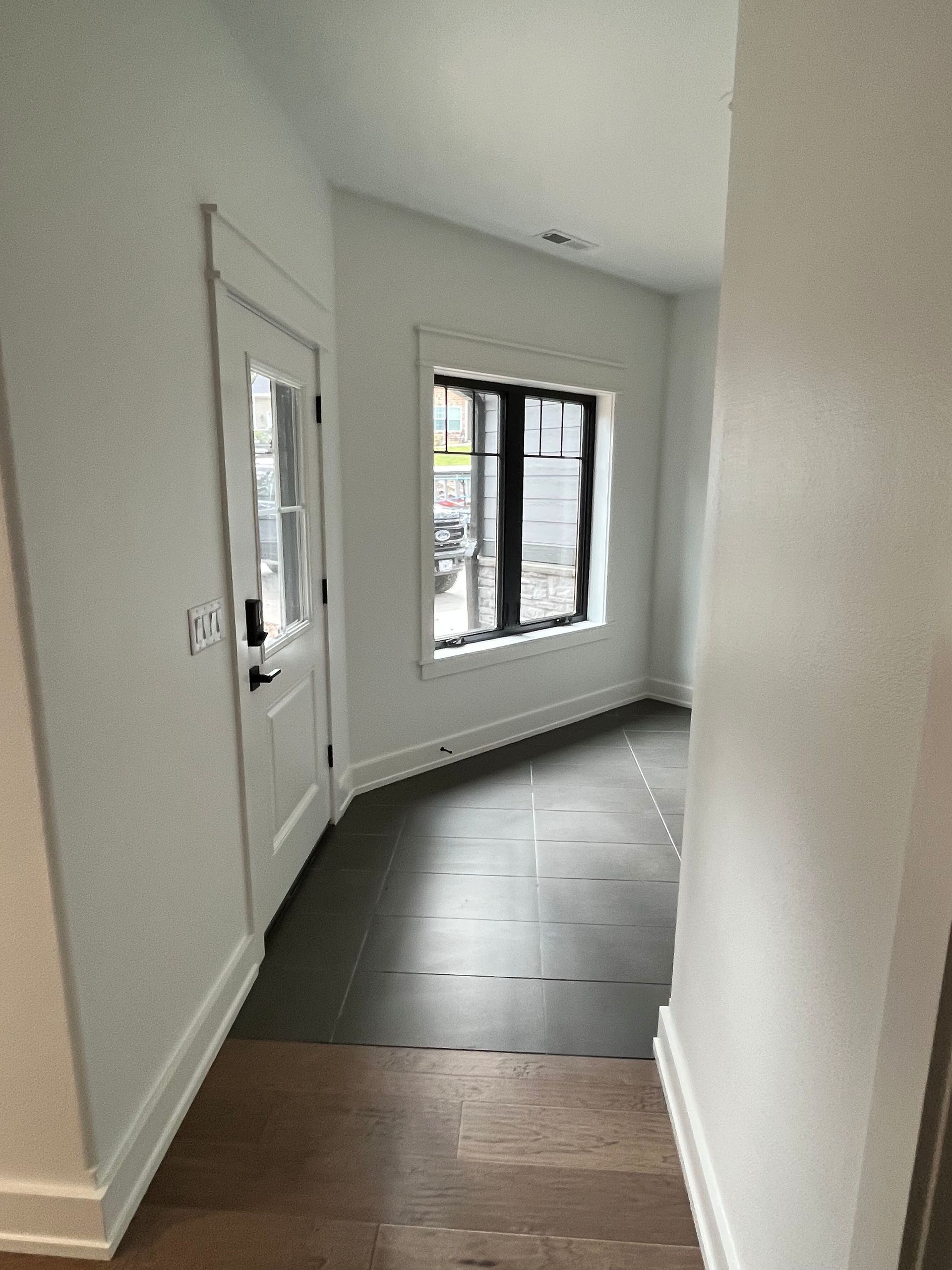 A hallway with a door and a window in a house.