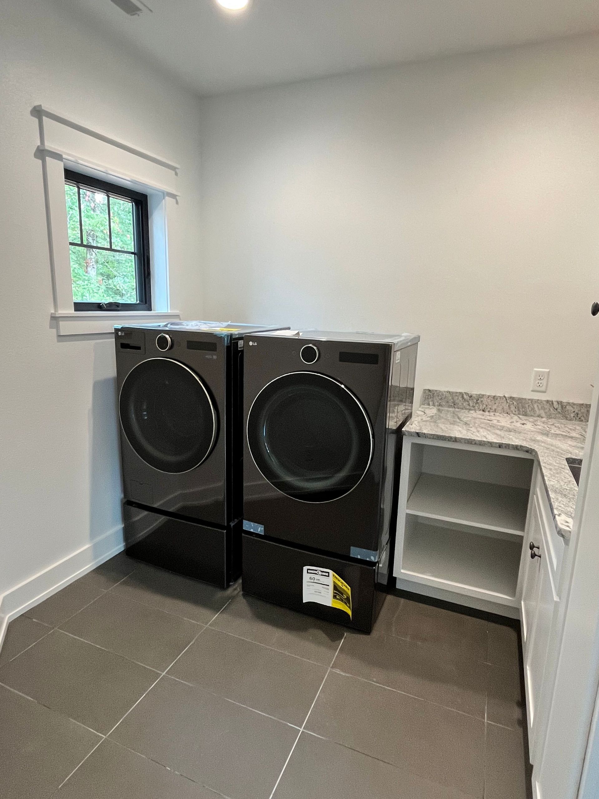 A laundry room with a washer and dryer and a window.