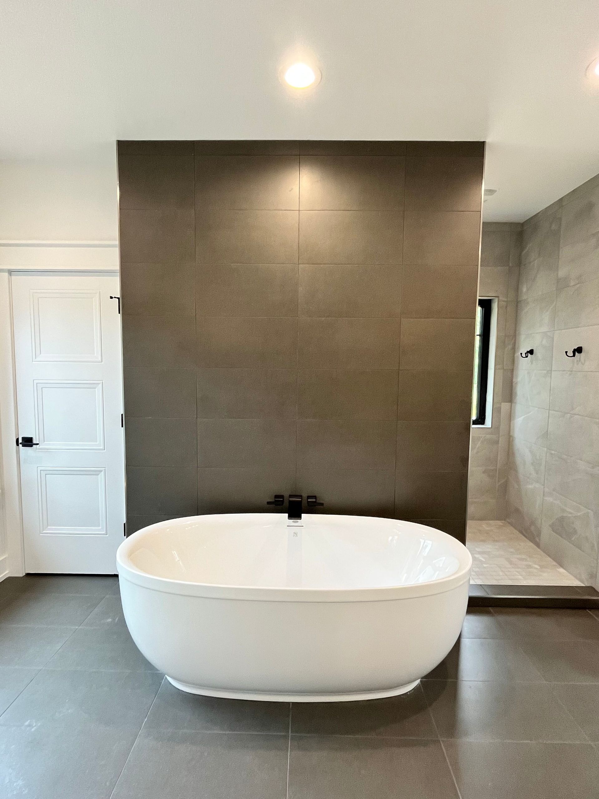 A white bathtub is sitting in a bathroom next to a wall.