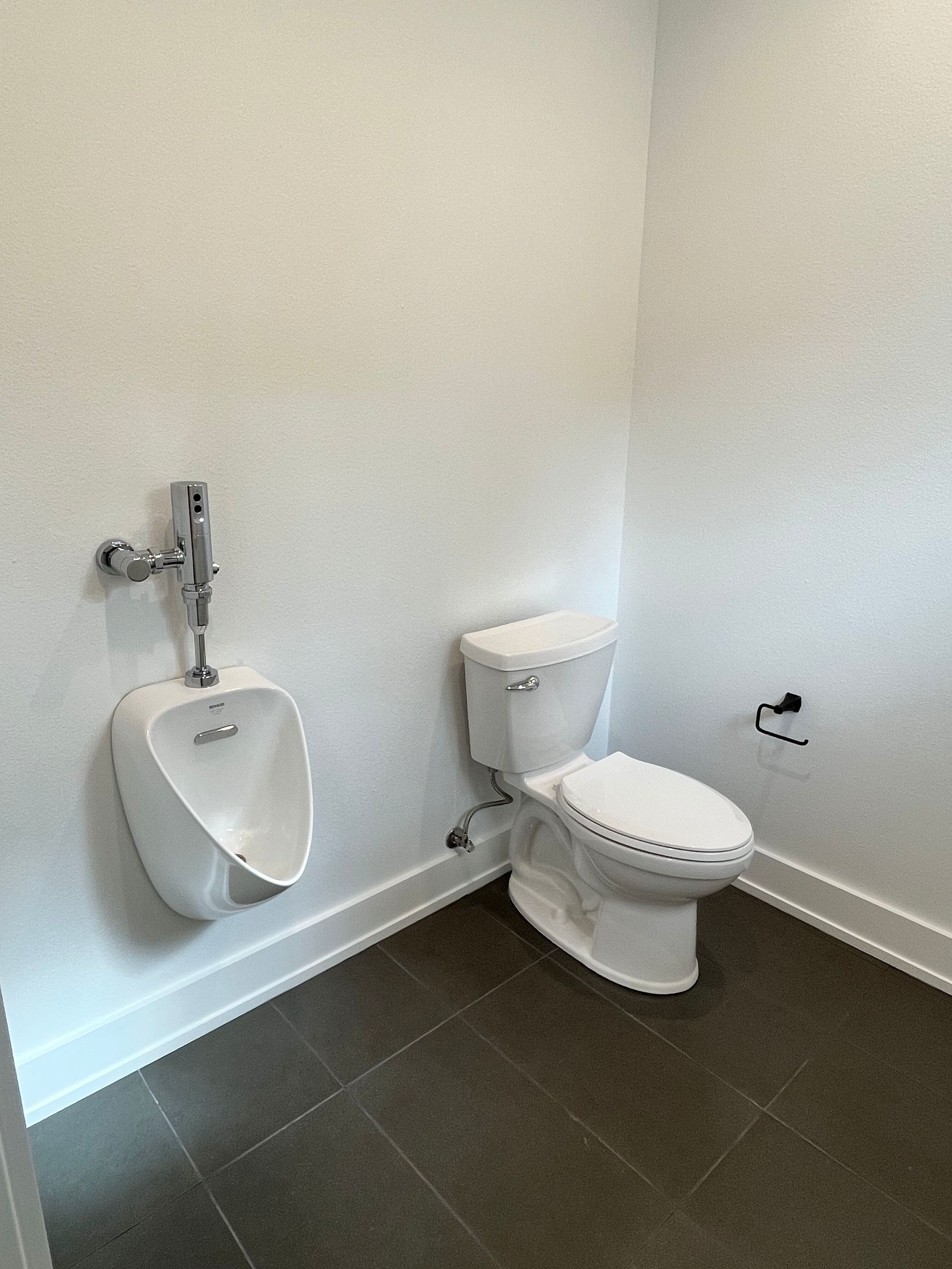 A bathroom with a toilet , urinal and sink.