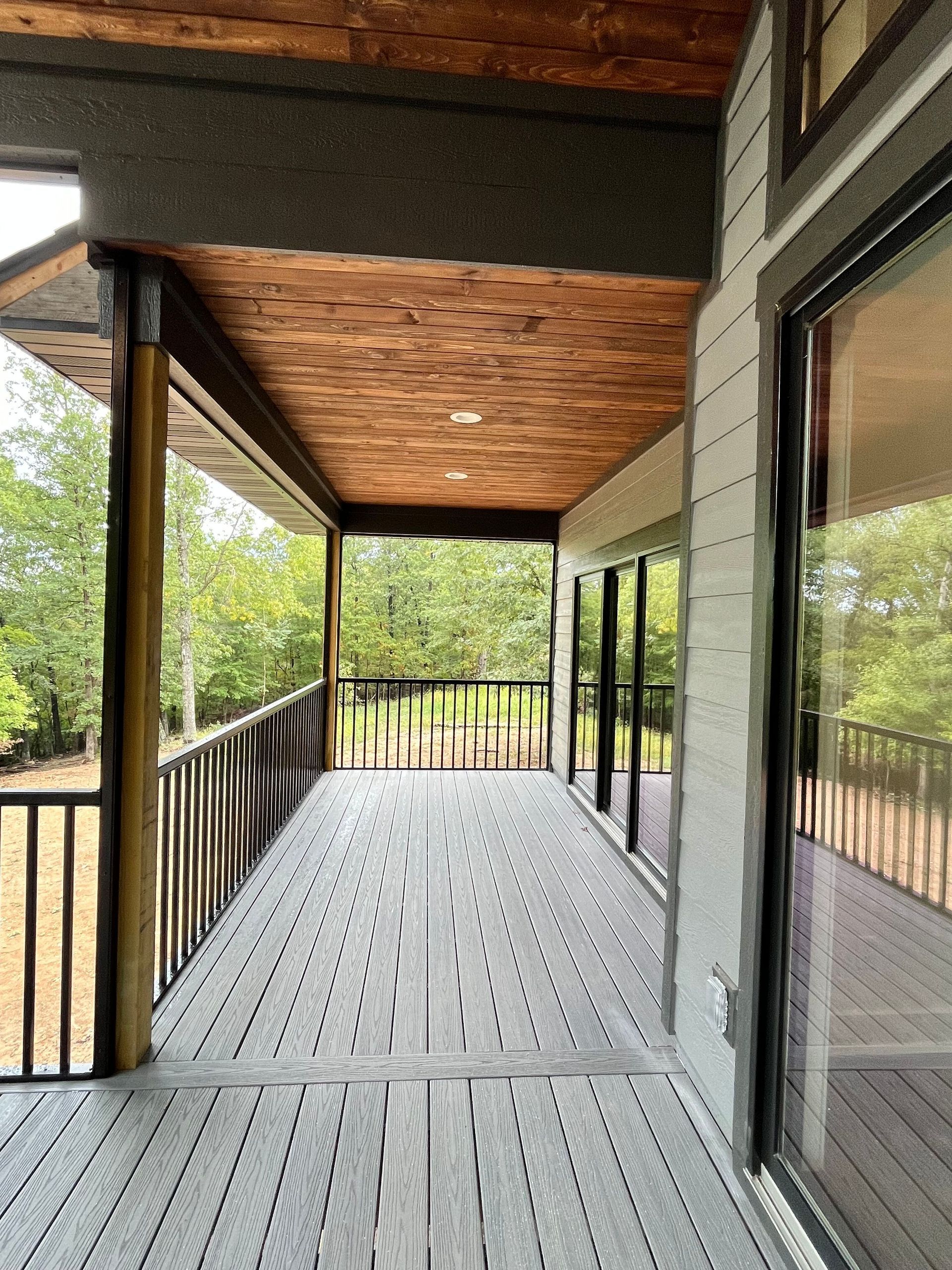 A large porch with a wooden ceiling and sliding glass doors