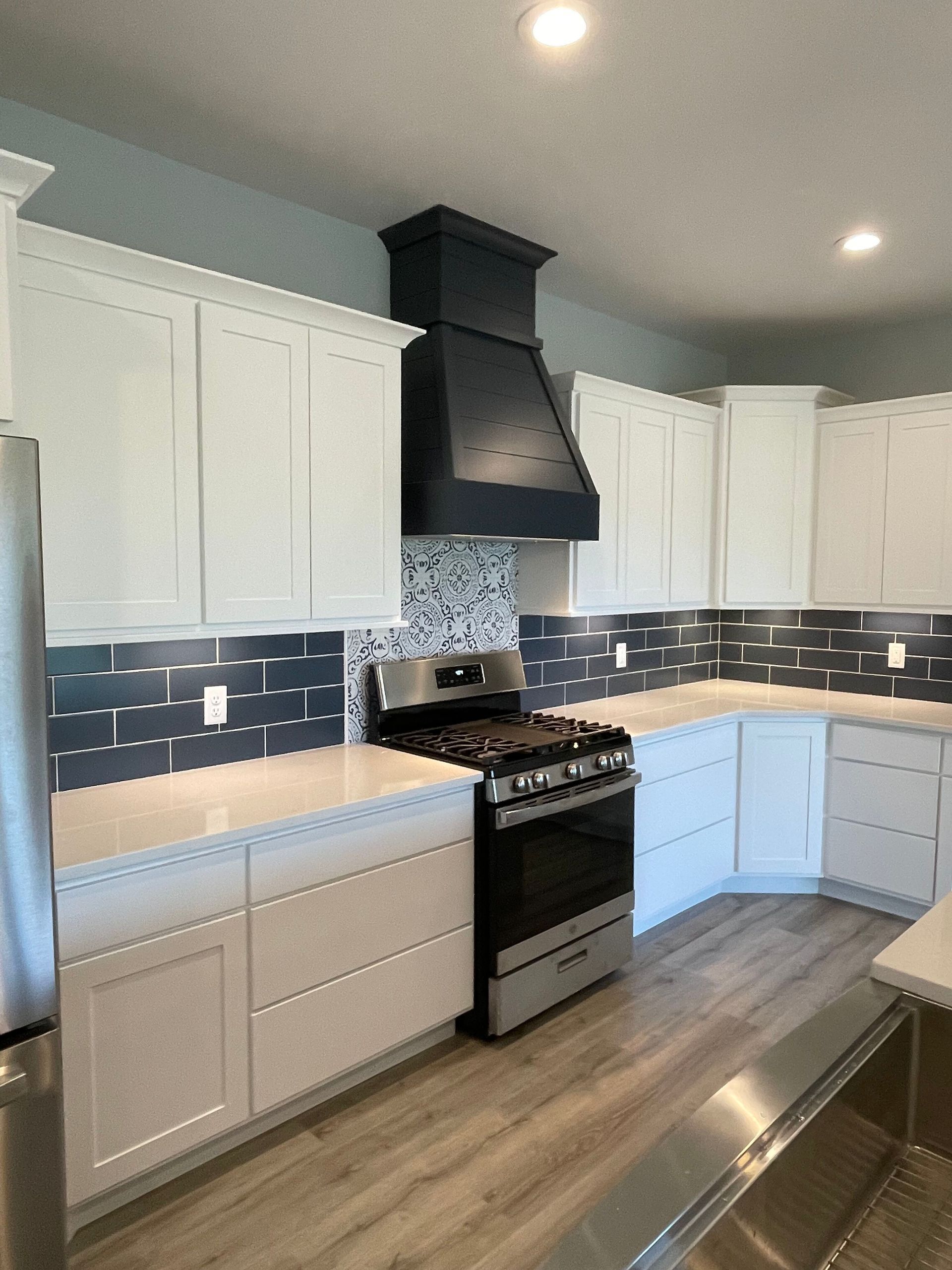 A kitchen with white cabinets and stainless steel appliances
