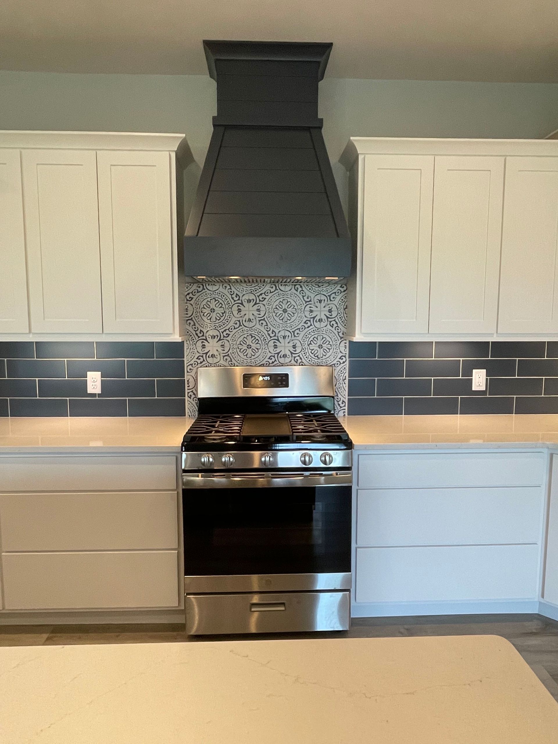 A kitchen with stainless steel appliances and white cabinets
