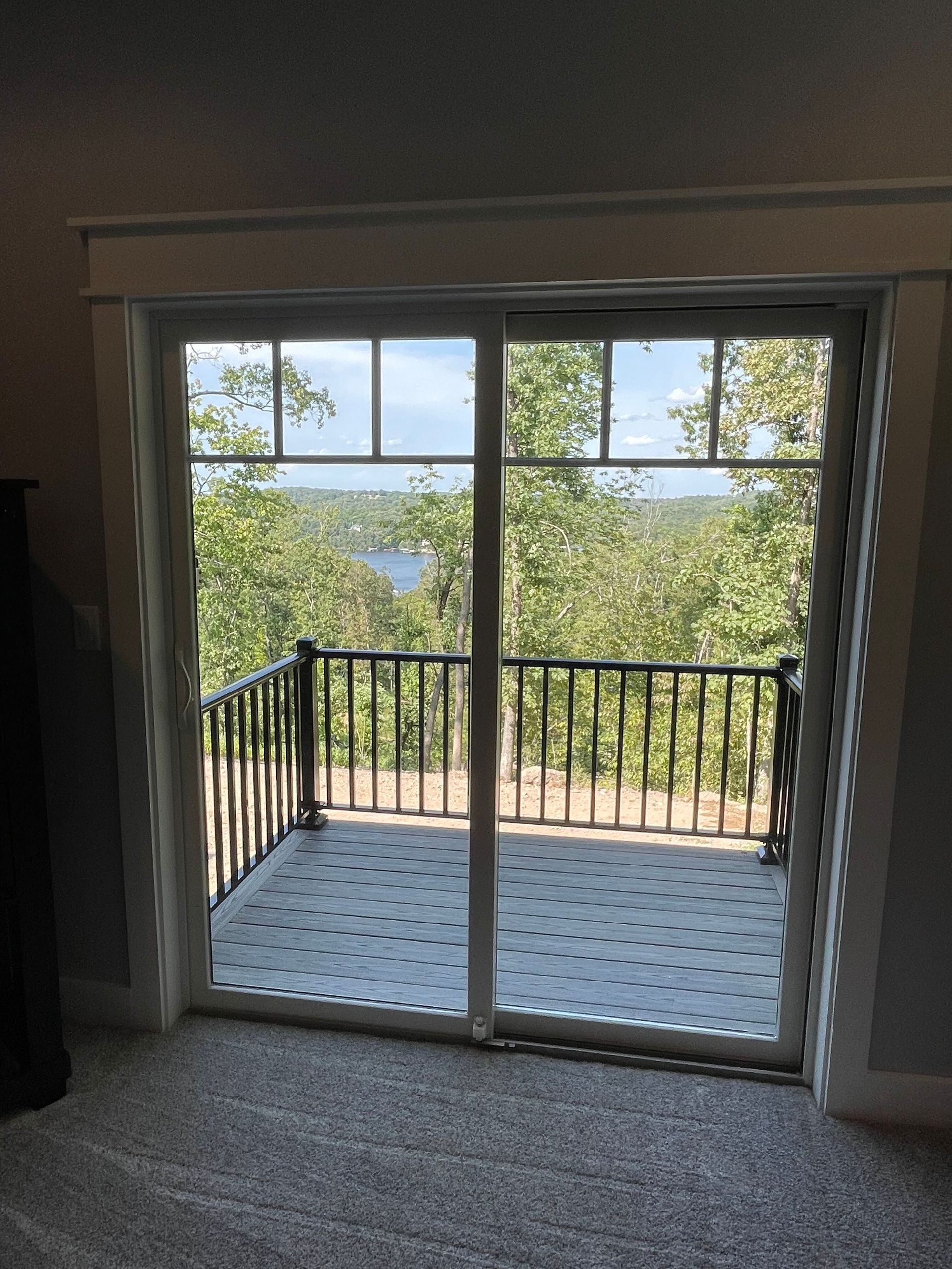 A sliding glass door leads to a balcony overlooking a lake