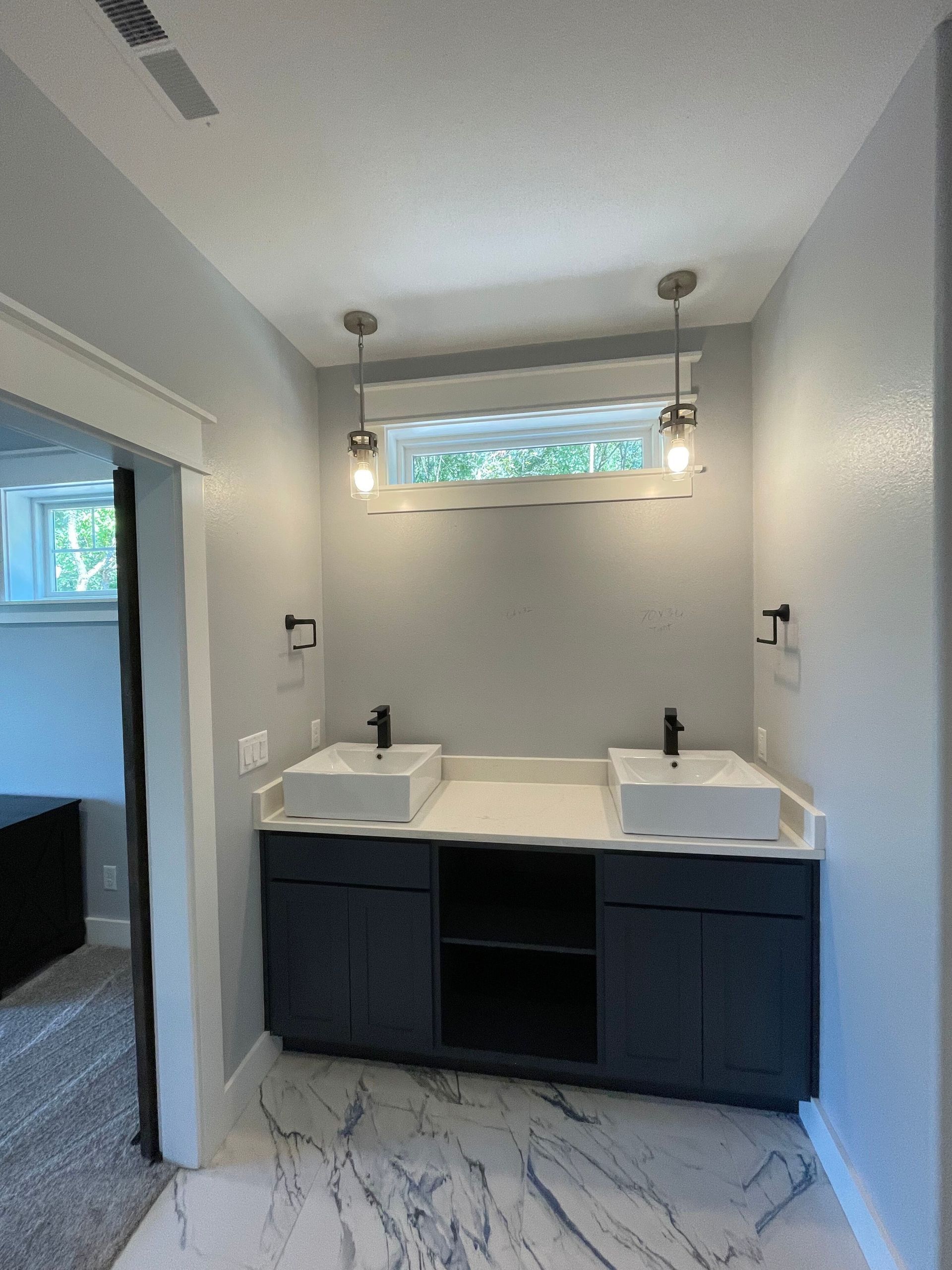 A bathroom with two sinks and a window