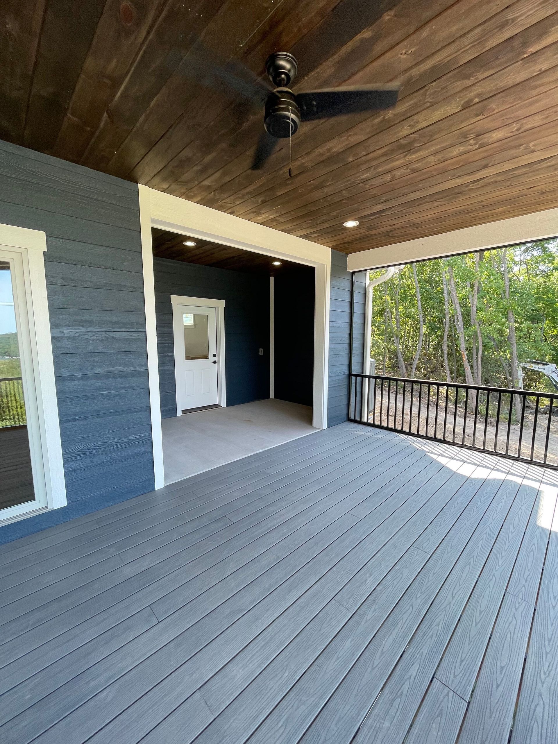 There is a ceiling fan on the porch of a house.