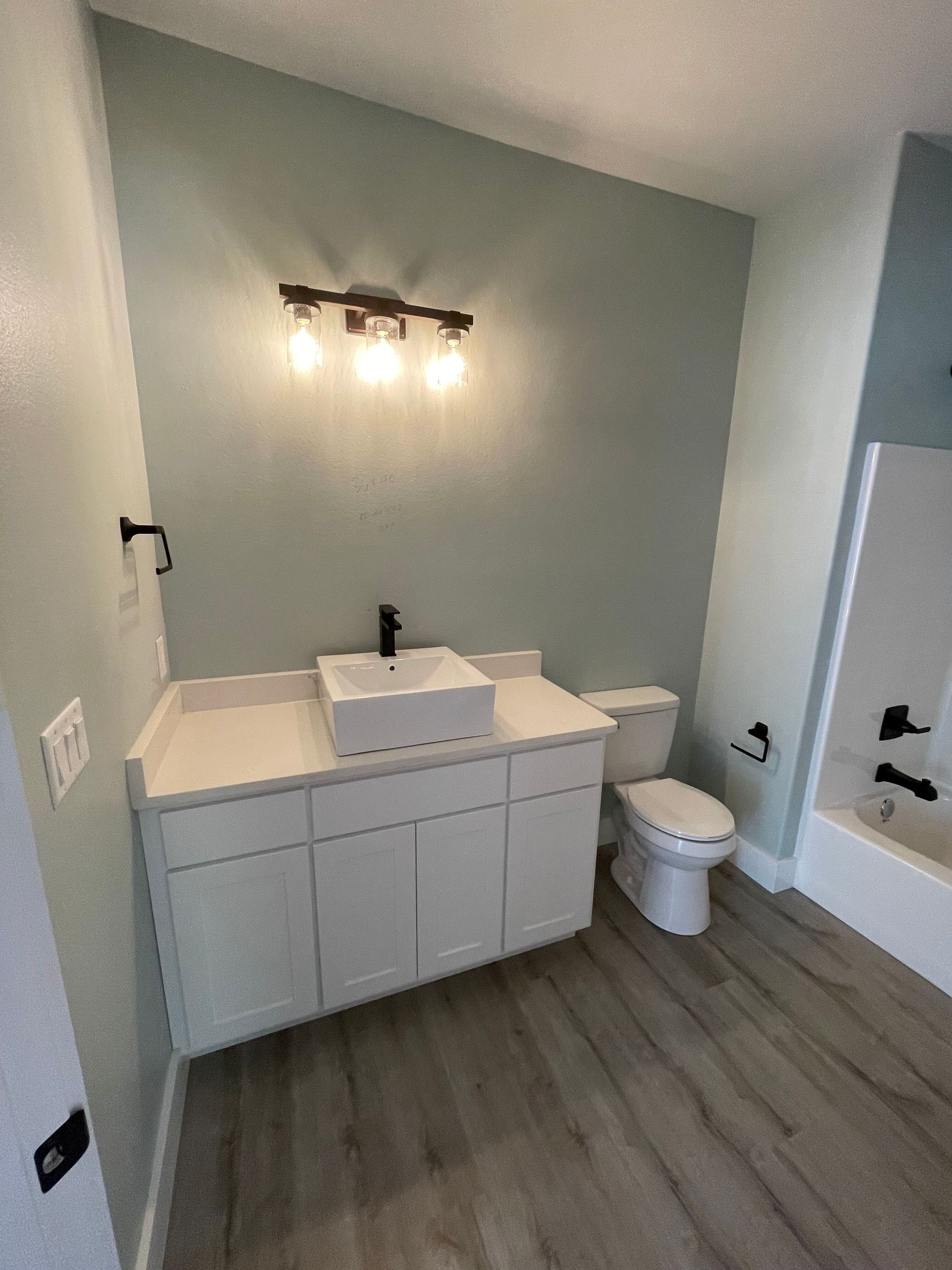 A bathroom with a sink , toilet , and bathtub.