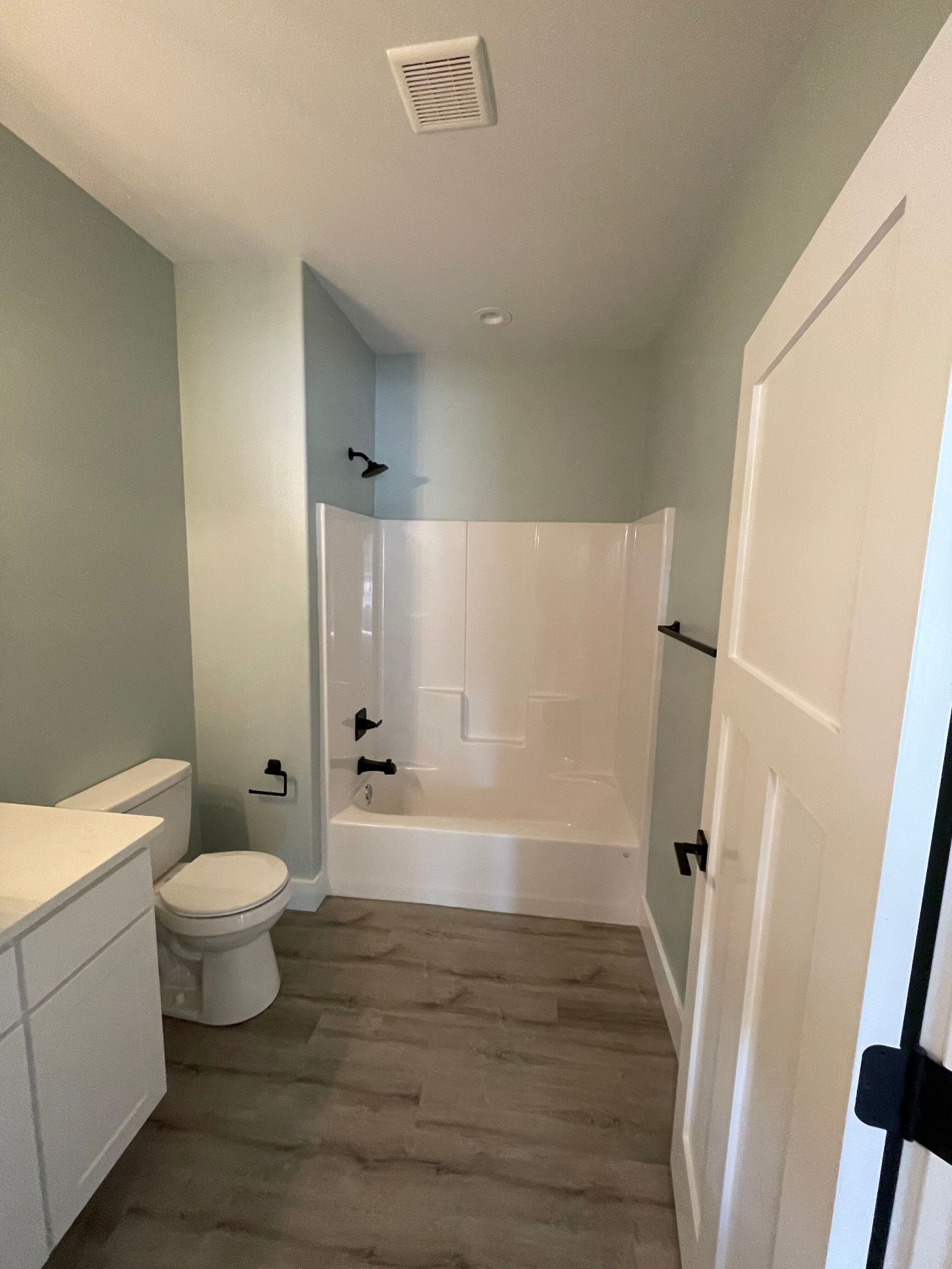 A bathroom with a toilet , sink , bathtub and shower.