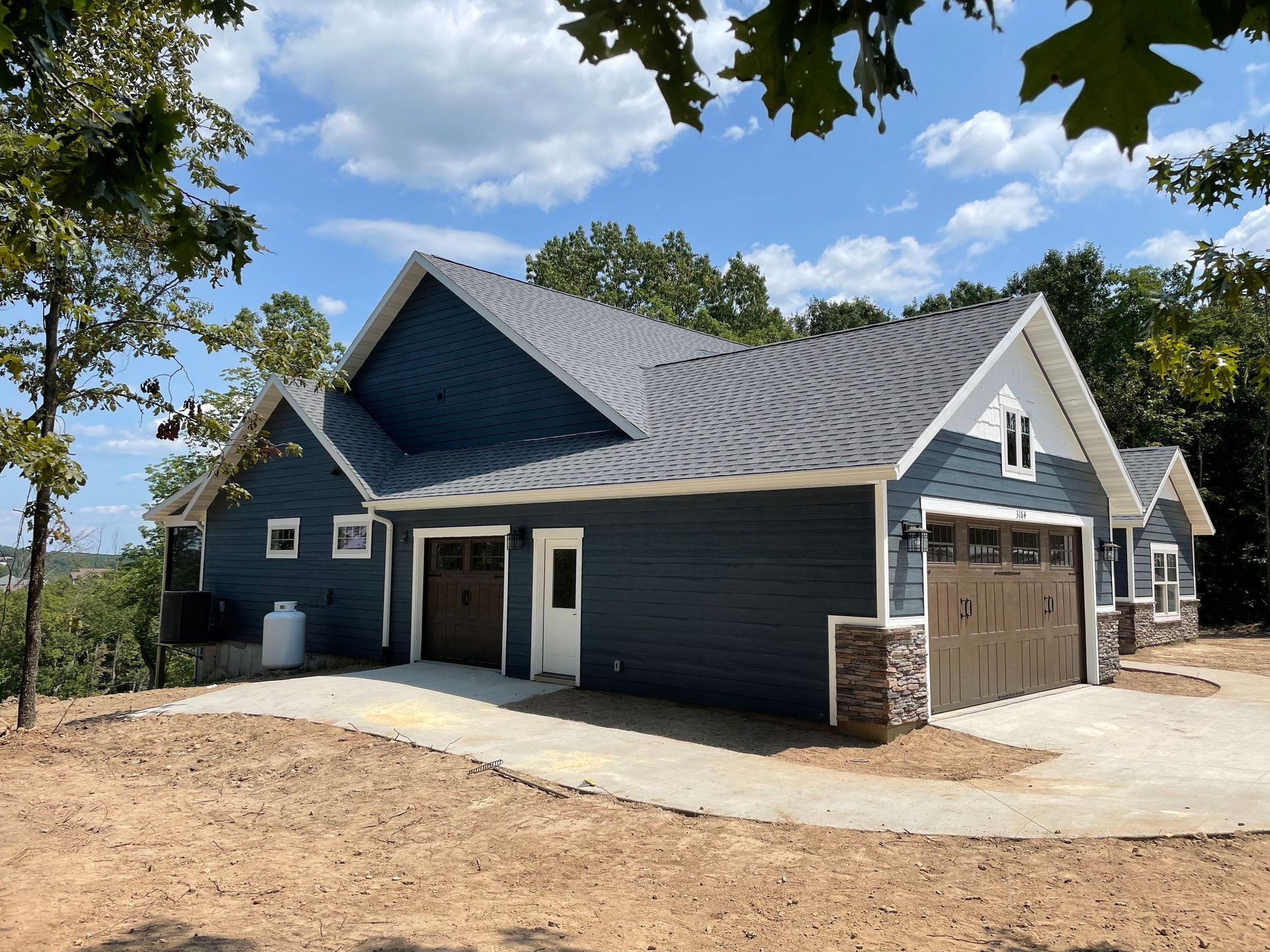 A blue house with a garage and a driveway
