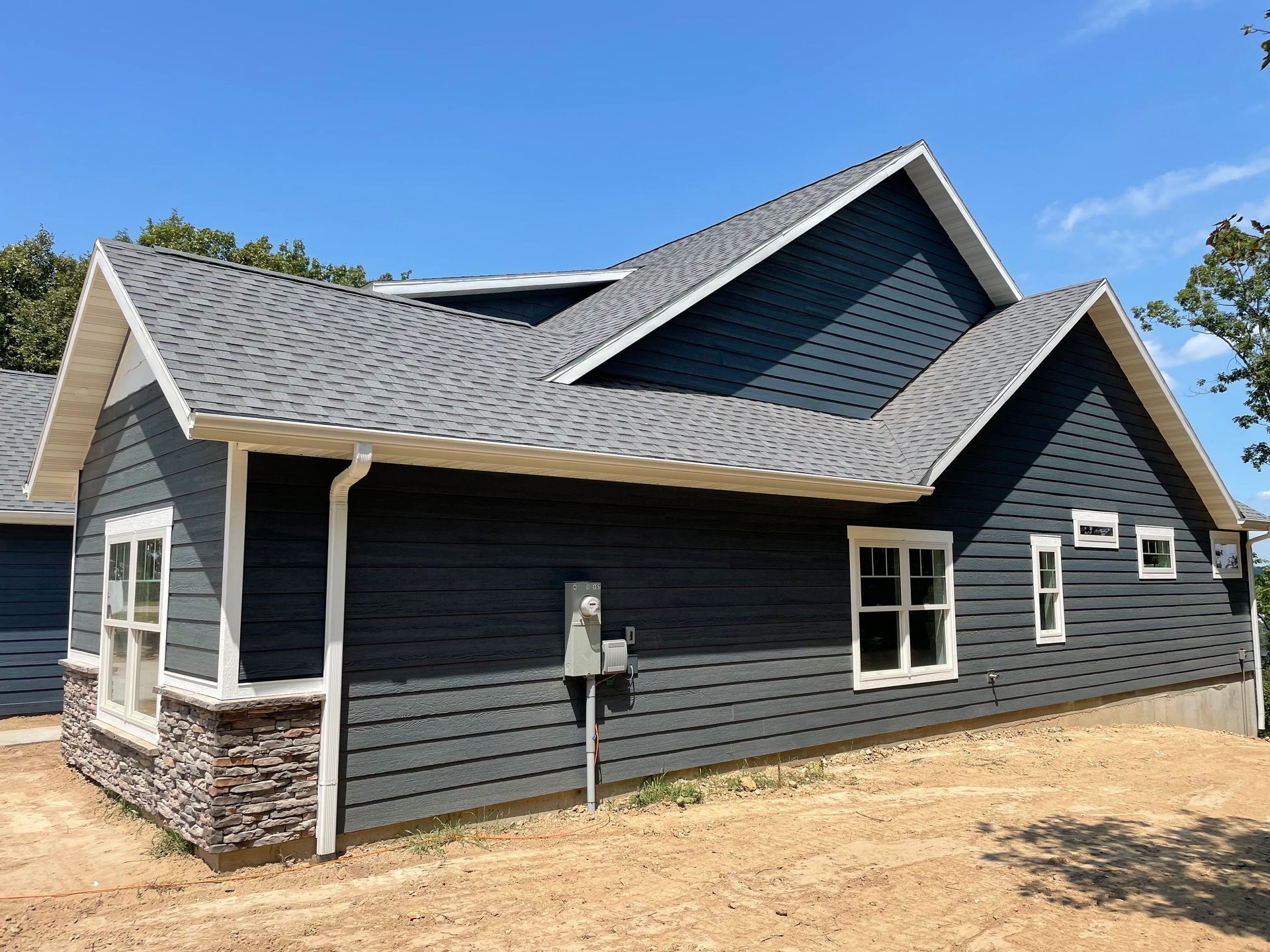 A black house with a gray roof and white trim